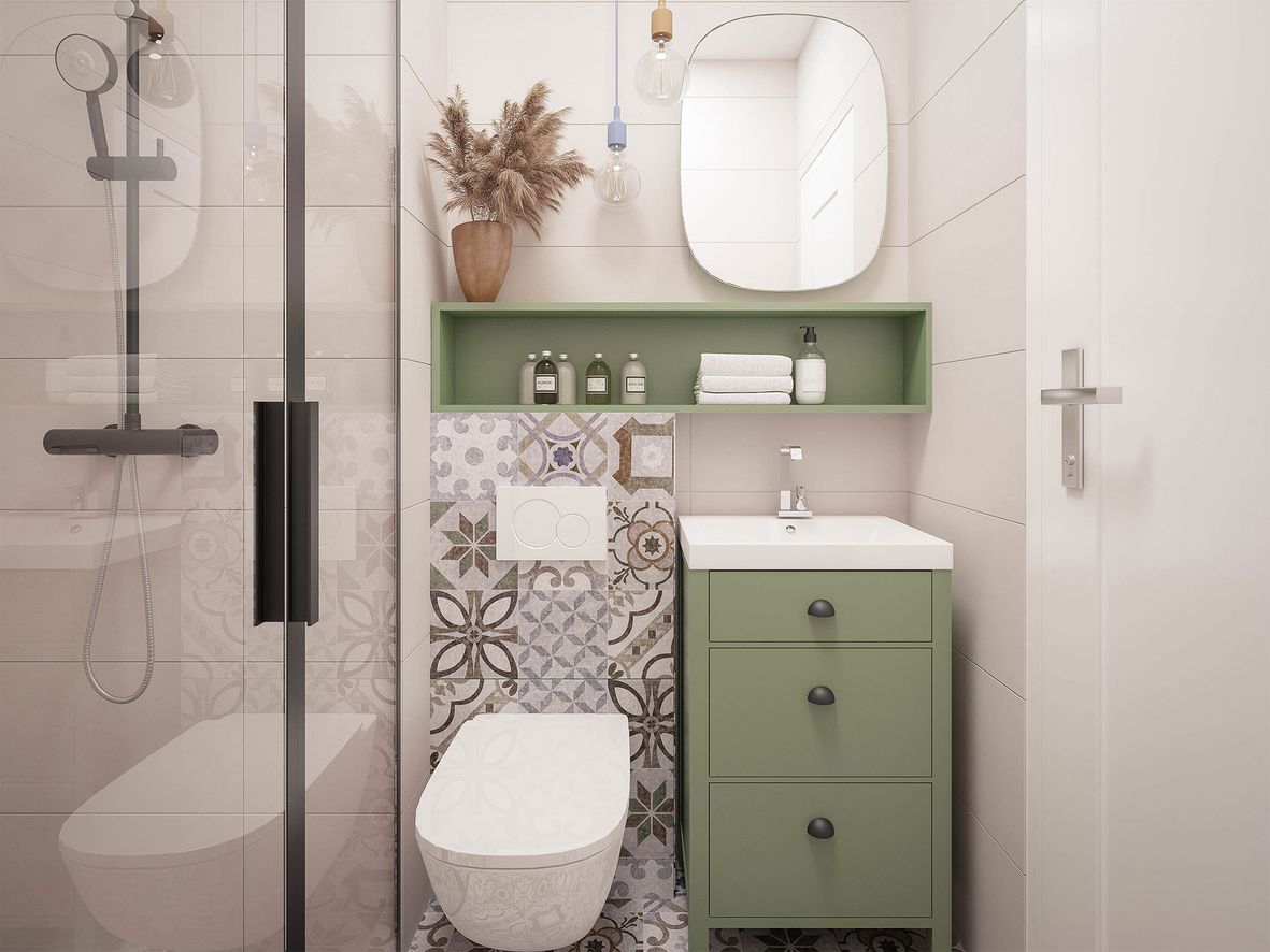small bathroom with patterned tiles and green cabinet