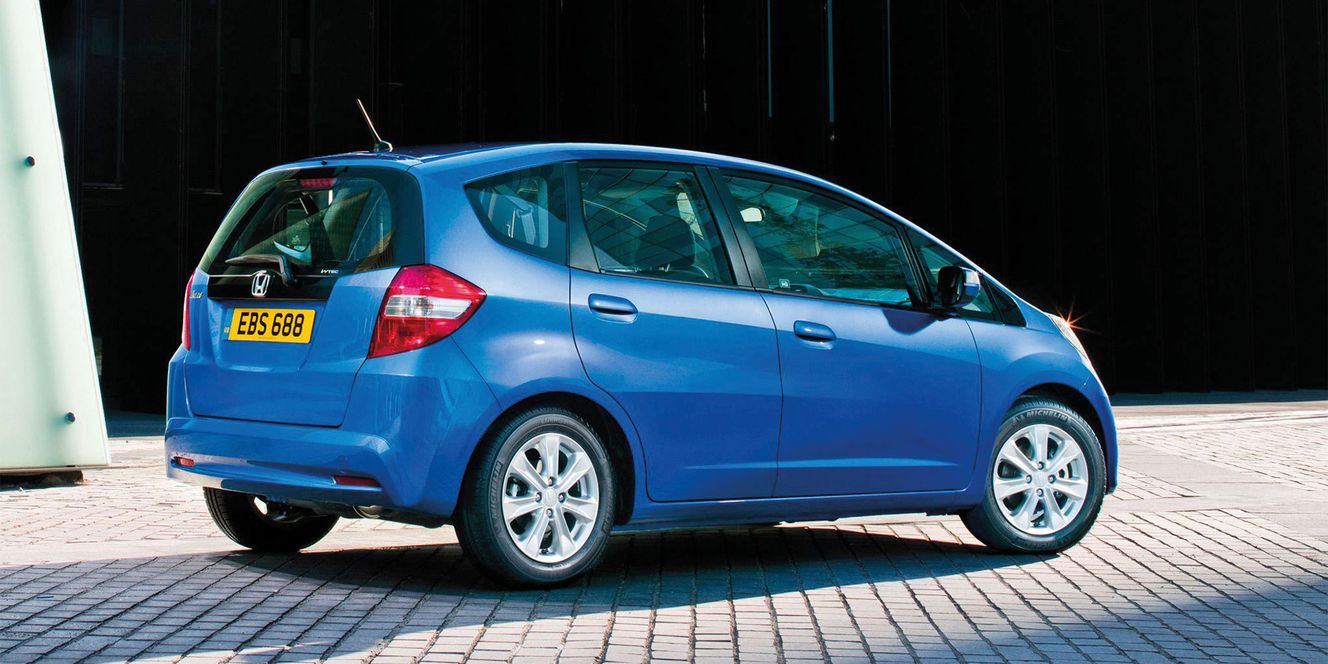 Blue Honda Jazz on paved road