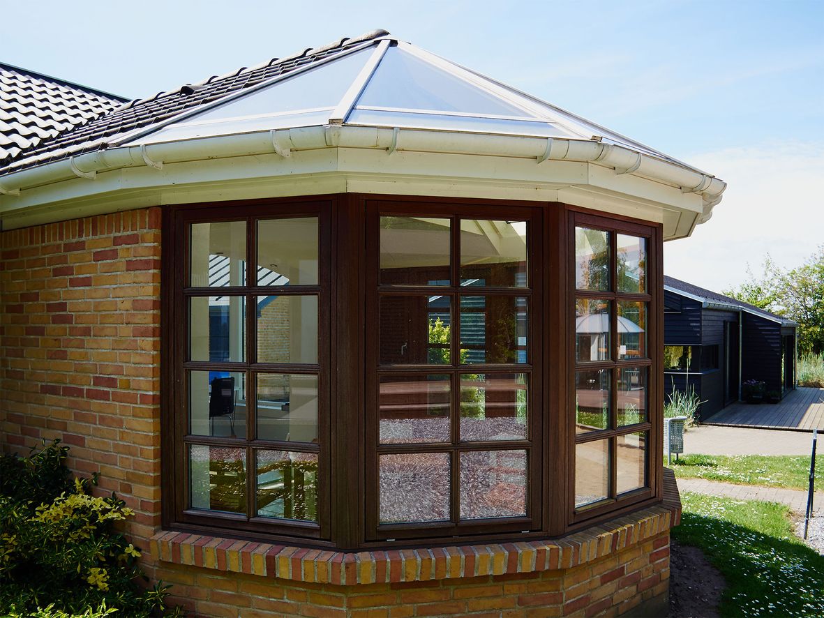 small orangery extension with rounded windows on a bungalow