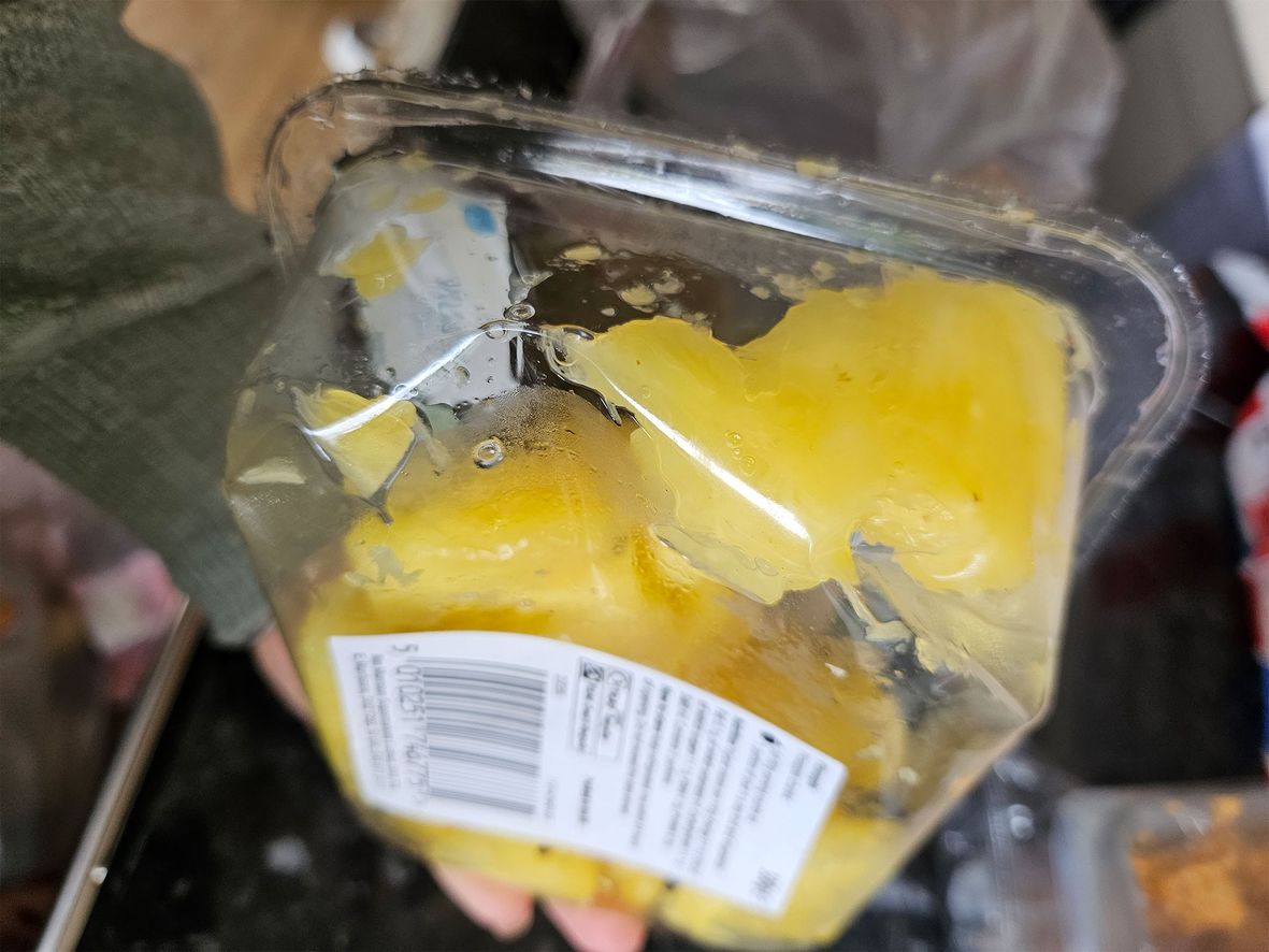 A bashed pot of pineapple from Morrisons that had leaked over other items and made them sticky
