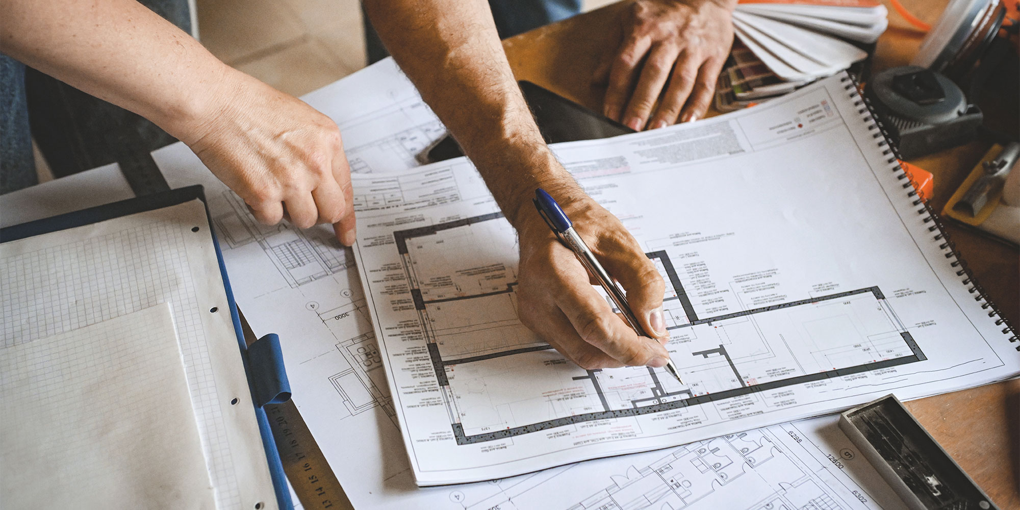 two people reviewing architectural plans for a home renovation