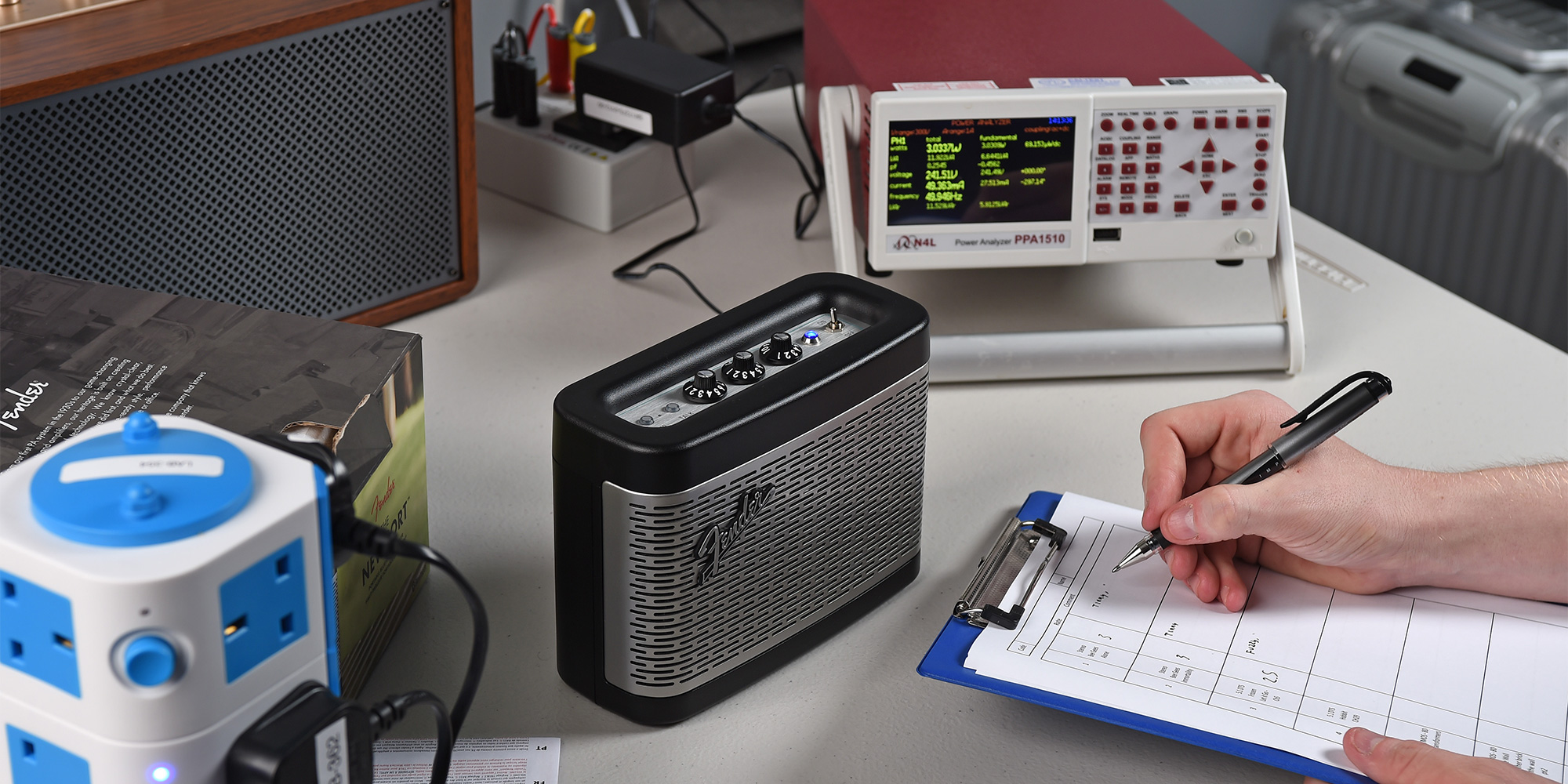 Person writing test results for sound quality on a clipboard next to the speaker being assessed.