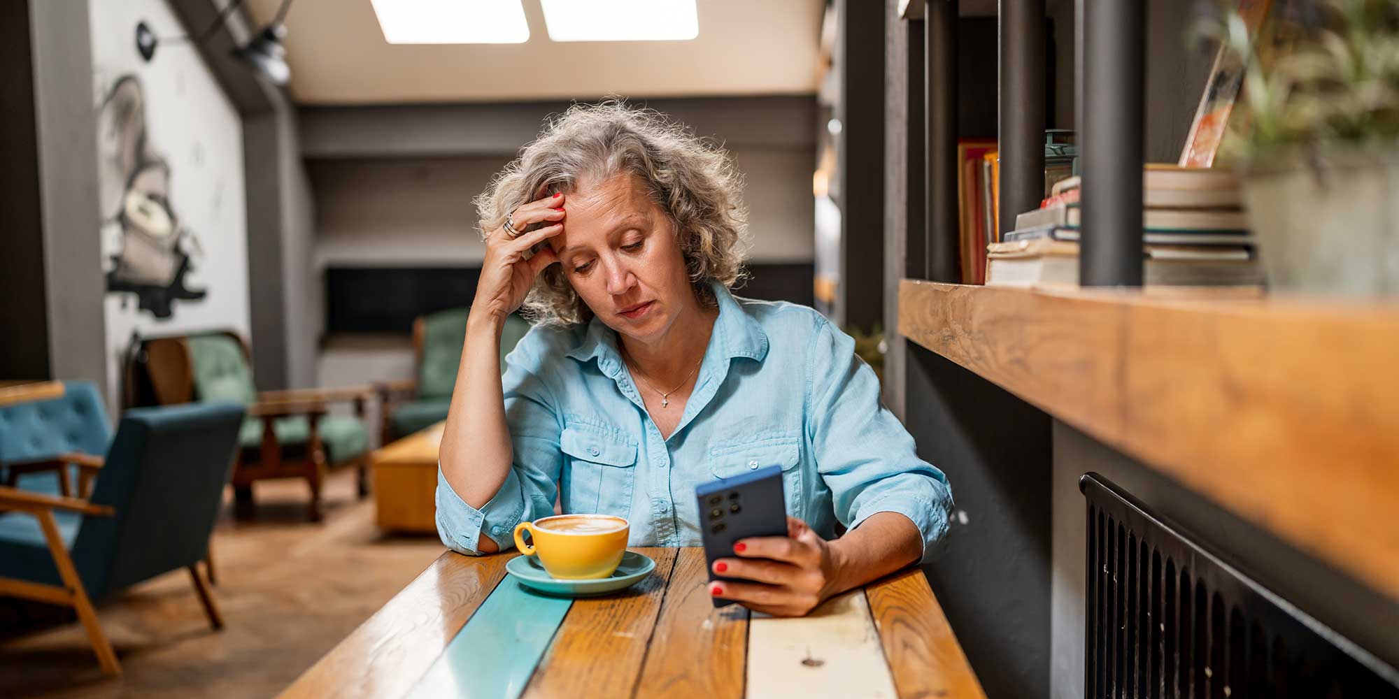 Grey-haired woman looking miffed at her mobile