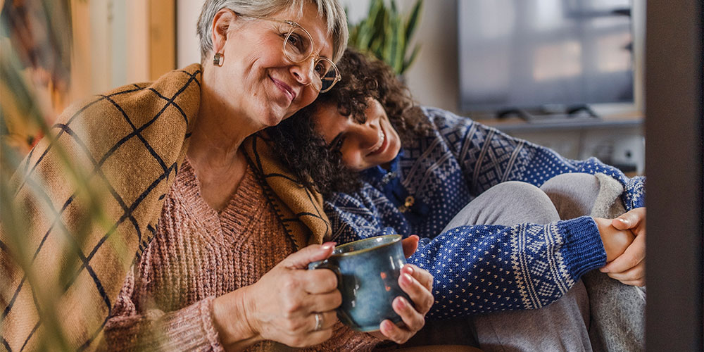 Two women cuddling in warm clothes and blankets