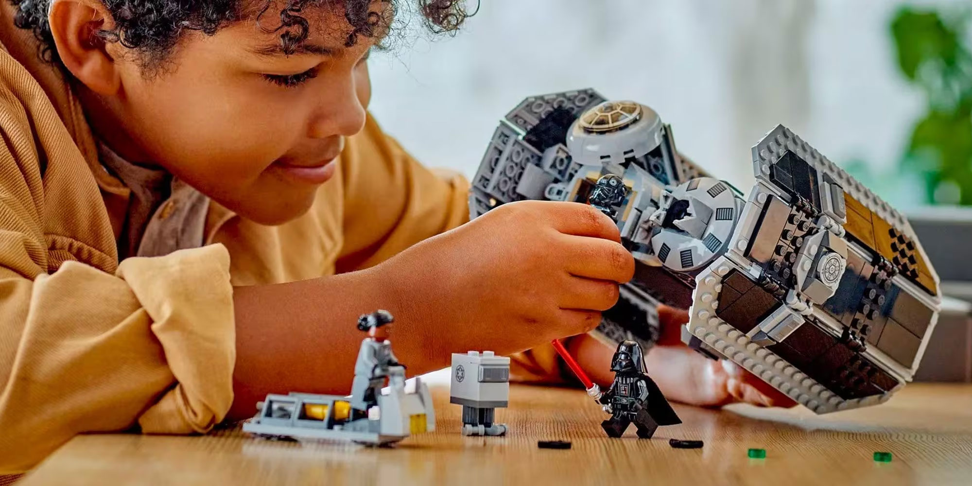 A young boy plays with a Lego Star Wars set