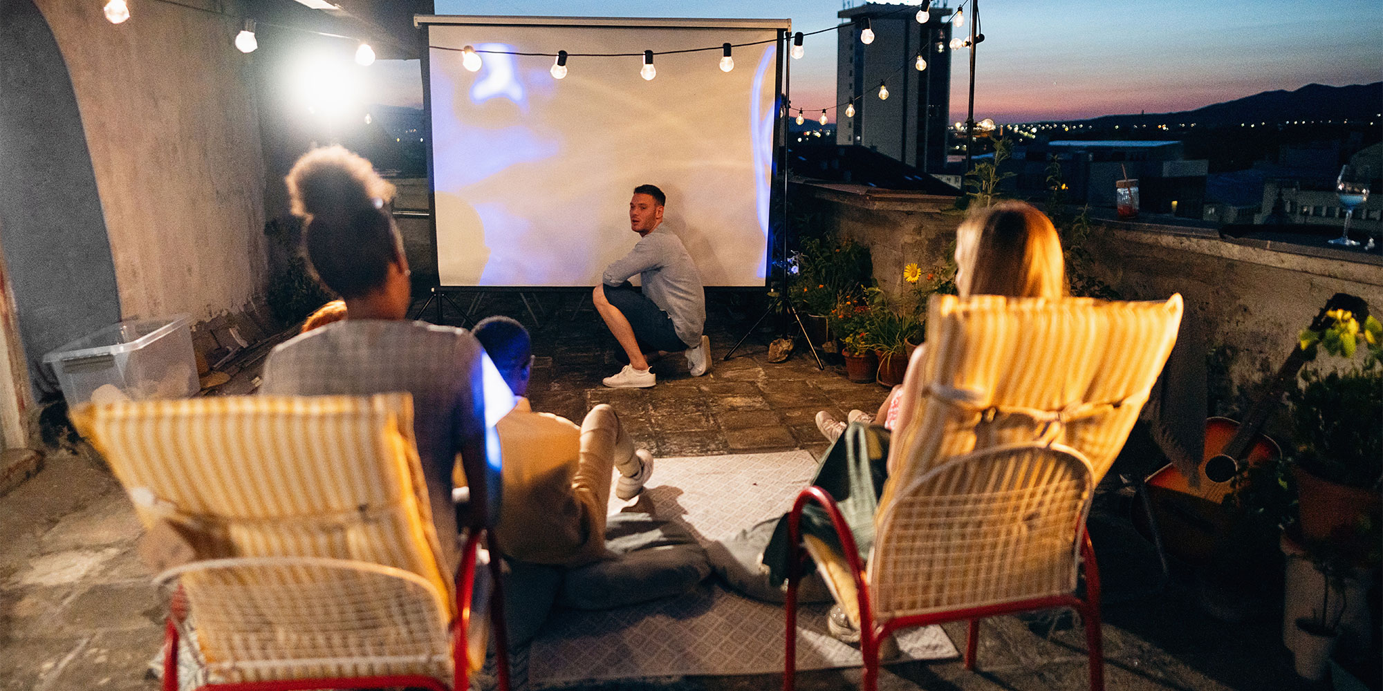 People setting up a projector outside