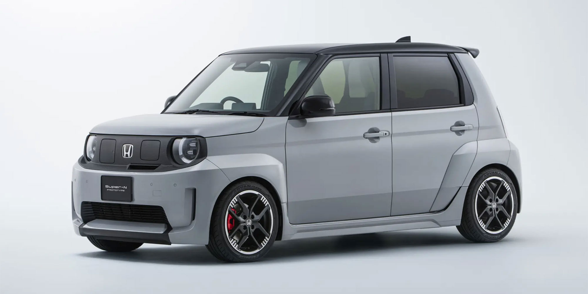 A black and grey Honda Super-N, parked against a white background