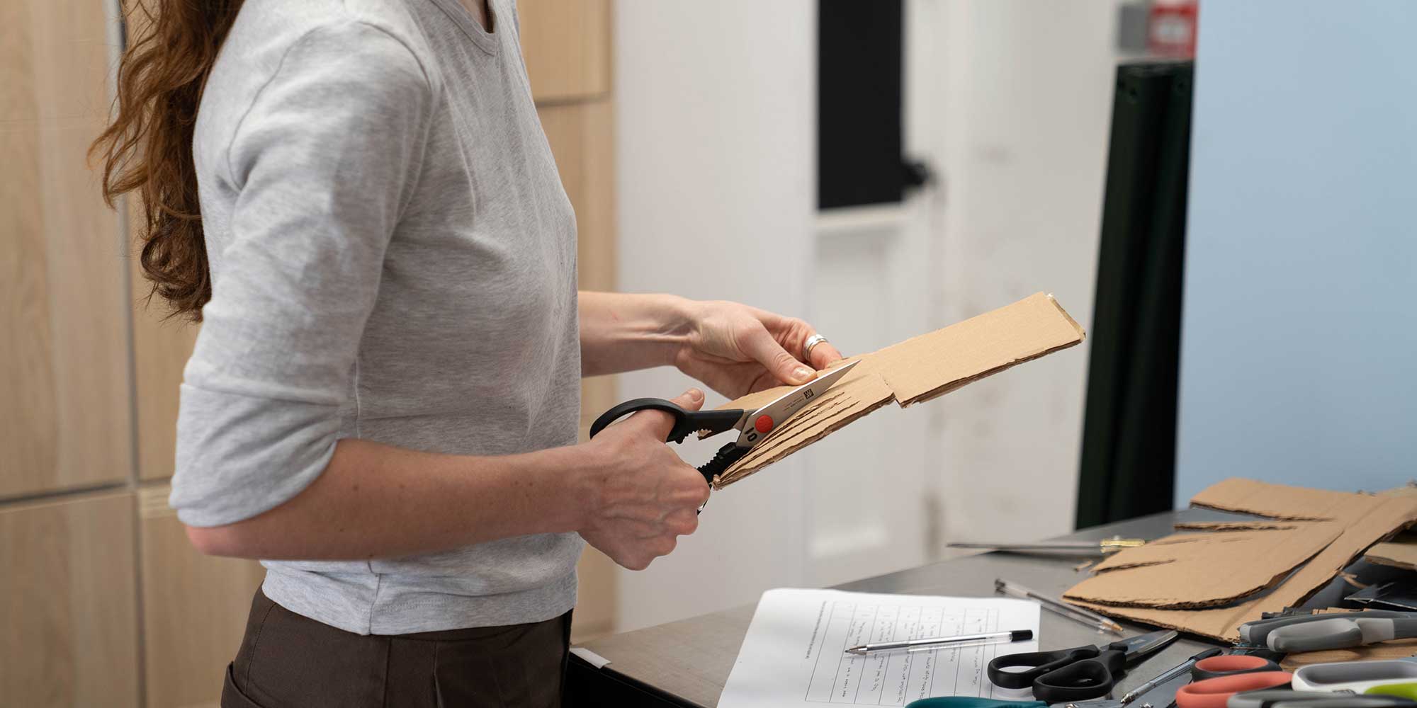 A Which? expert tester cuts cardboard packaging to assess handle comfort