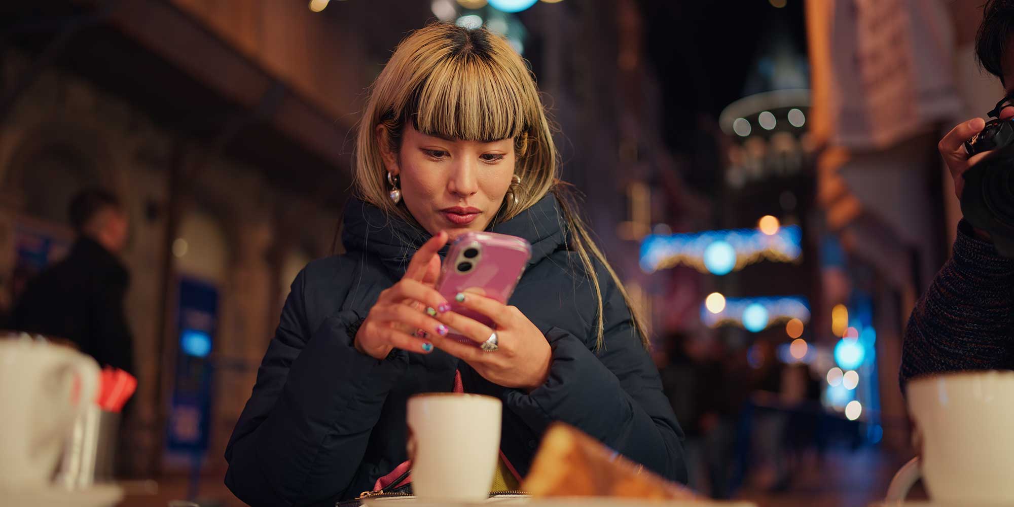 A person using their mobile phone in a cafe