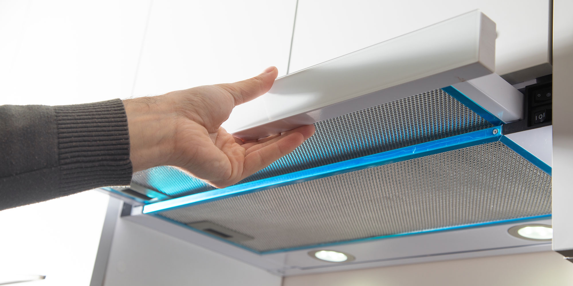 Someone pulling out the front panel of a telescopic cooker hood