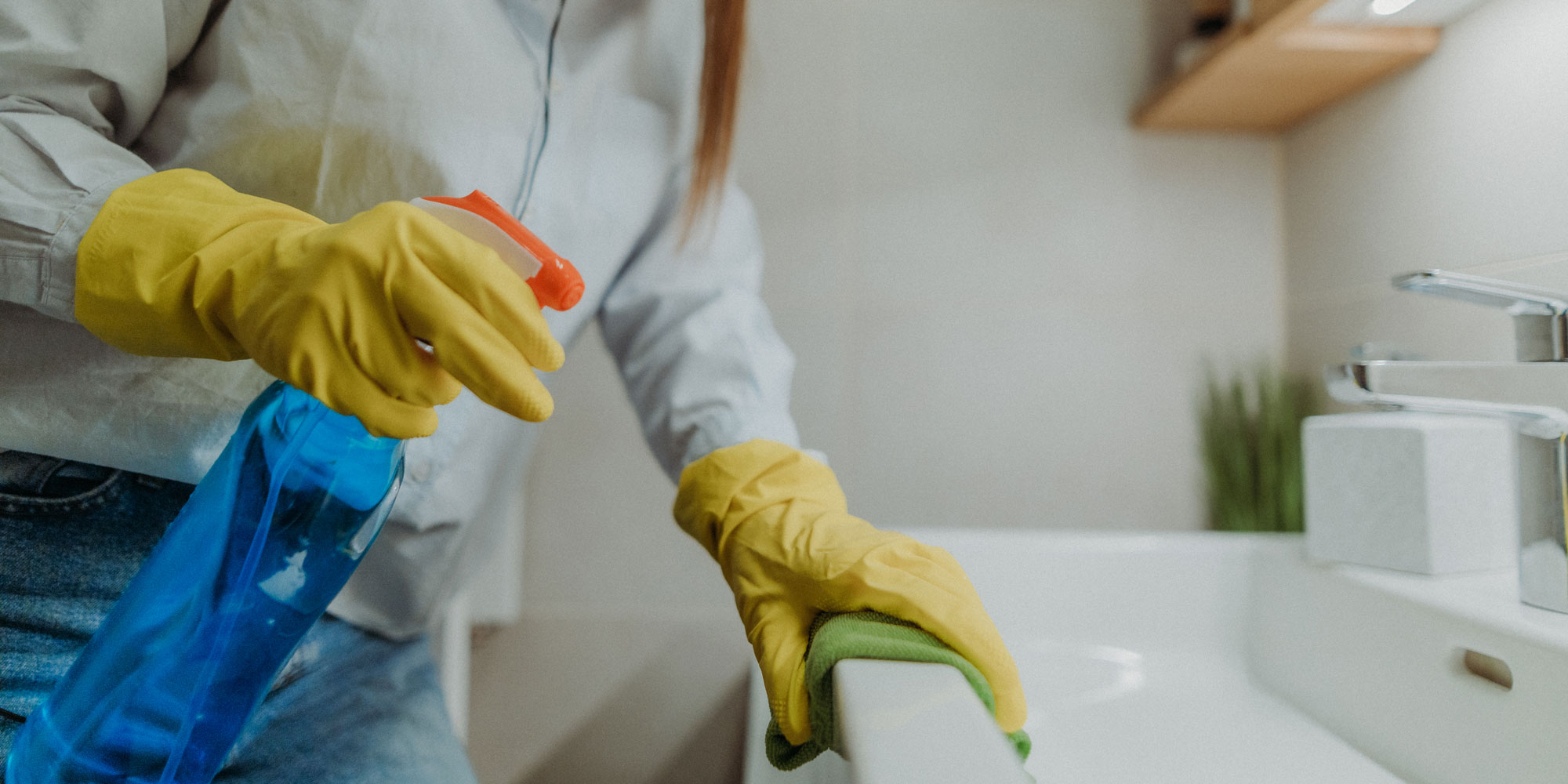 person wiping a bathroom sink