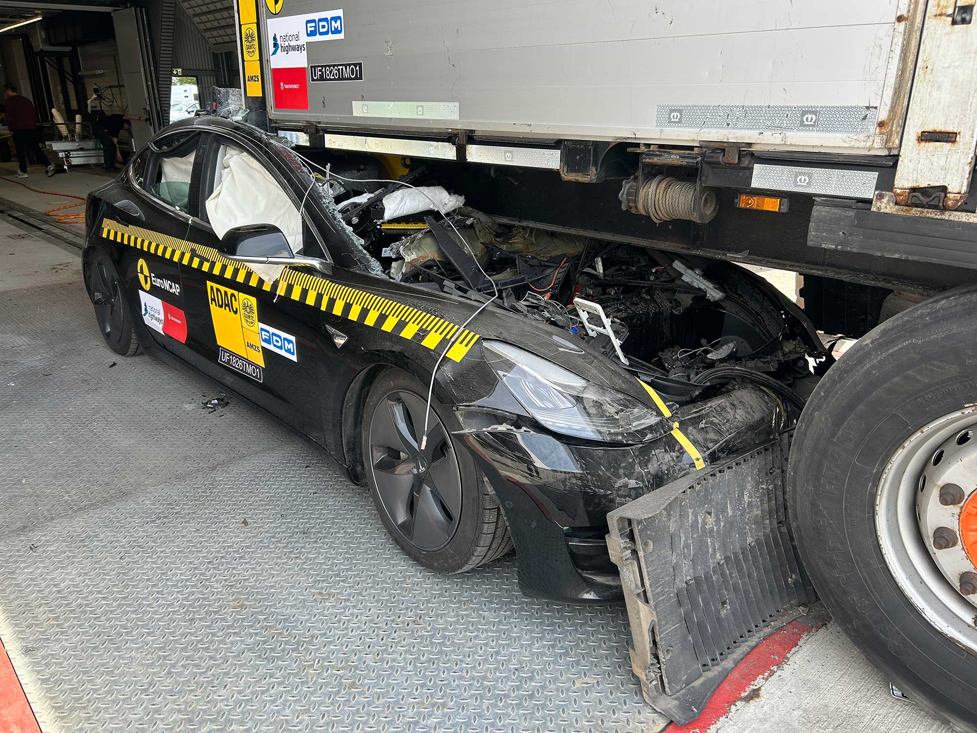The aftermath of a full-frontal crash test against a European truck trailer. The entire car's passenger compartment is crushed.