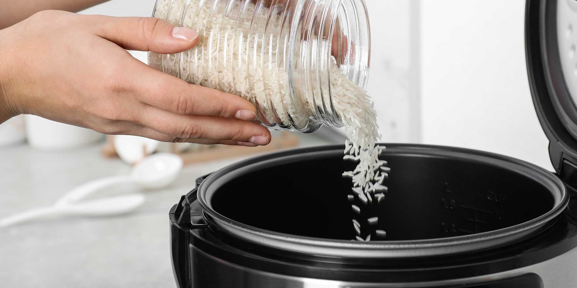 rice being poured into a rice cooker