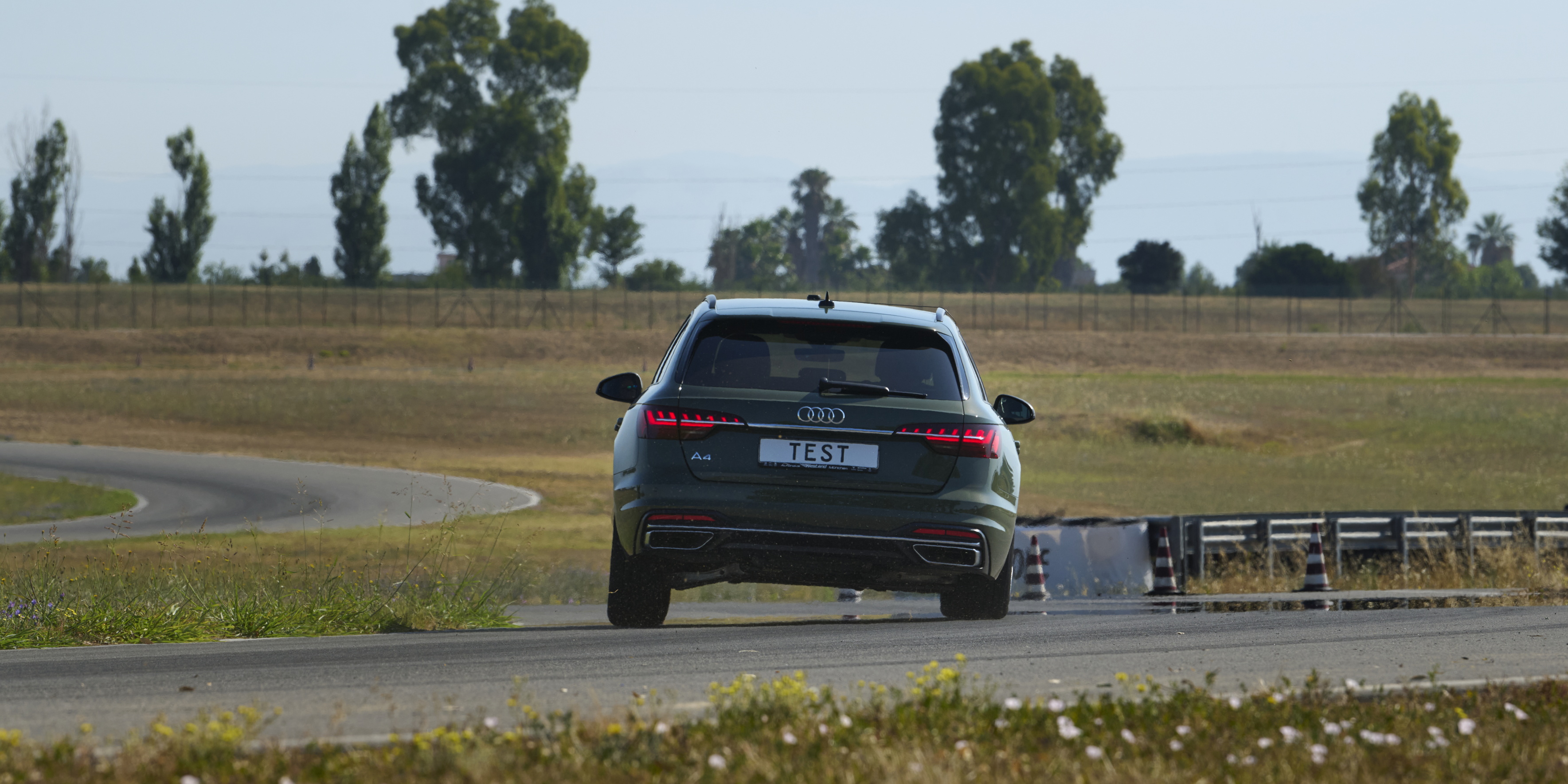 Car being driven on dry road track to test tyre performance