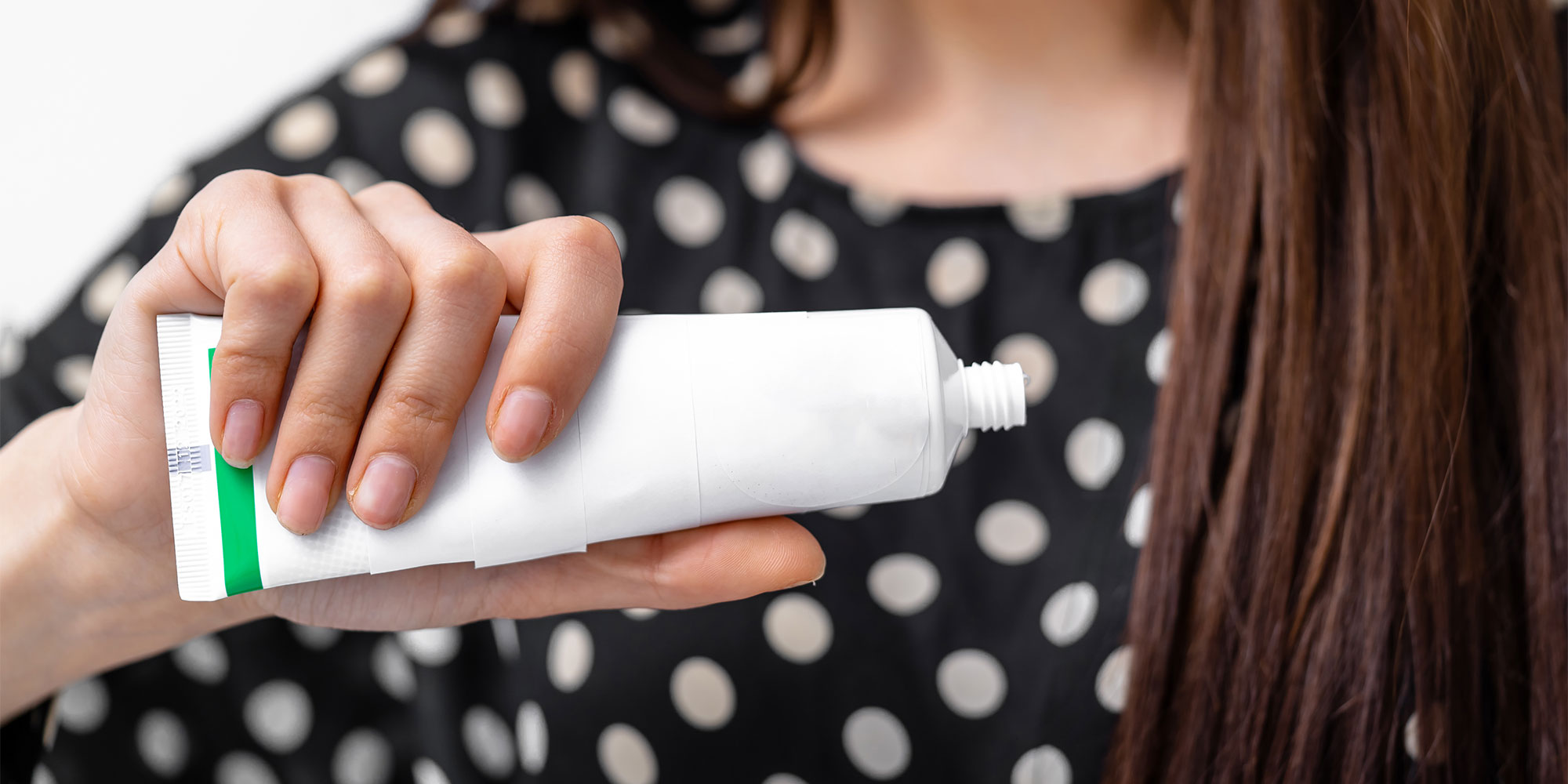 Someone checking the expiry on a tube of toothpaste