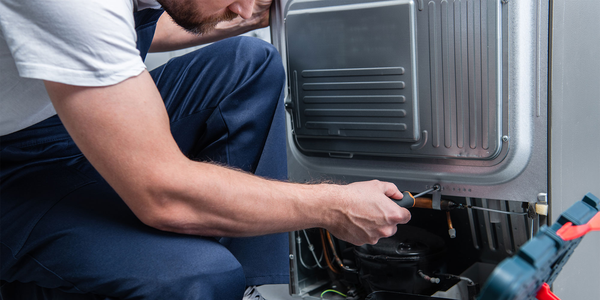 Technician repairing a fridge freezer