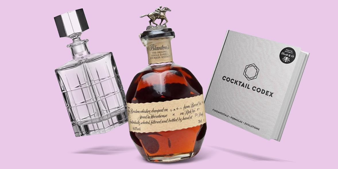 A decanter, bottle of bourbon, and cocktail book
