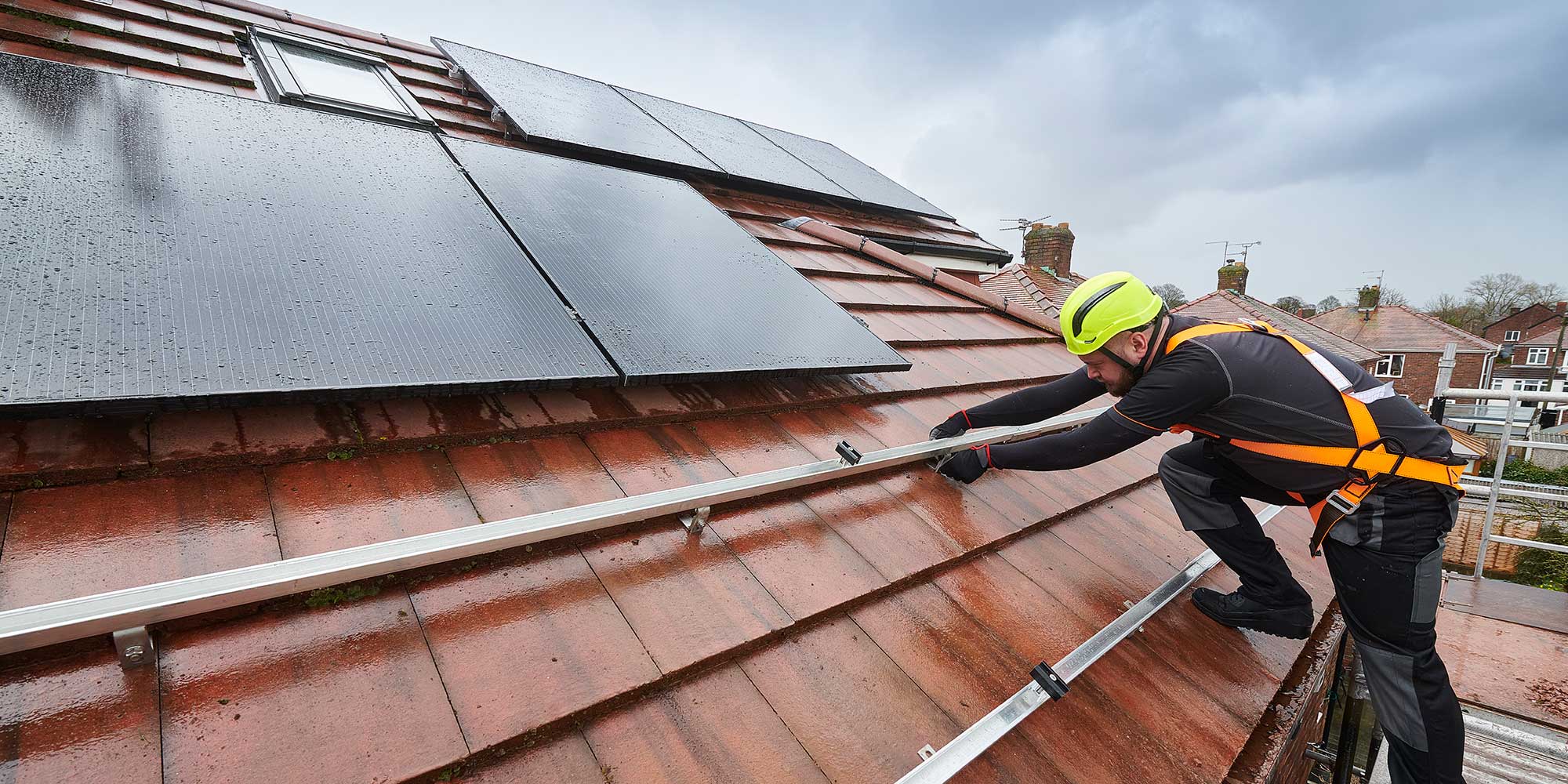 Tradesperson installing solar panels on roof