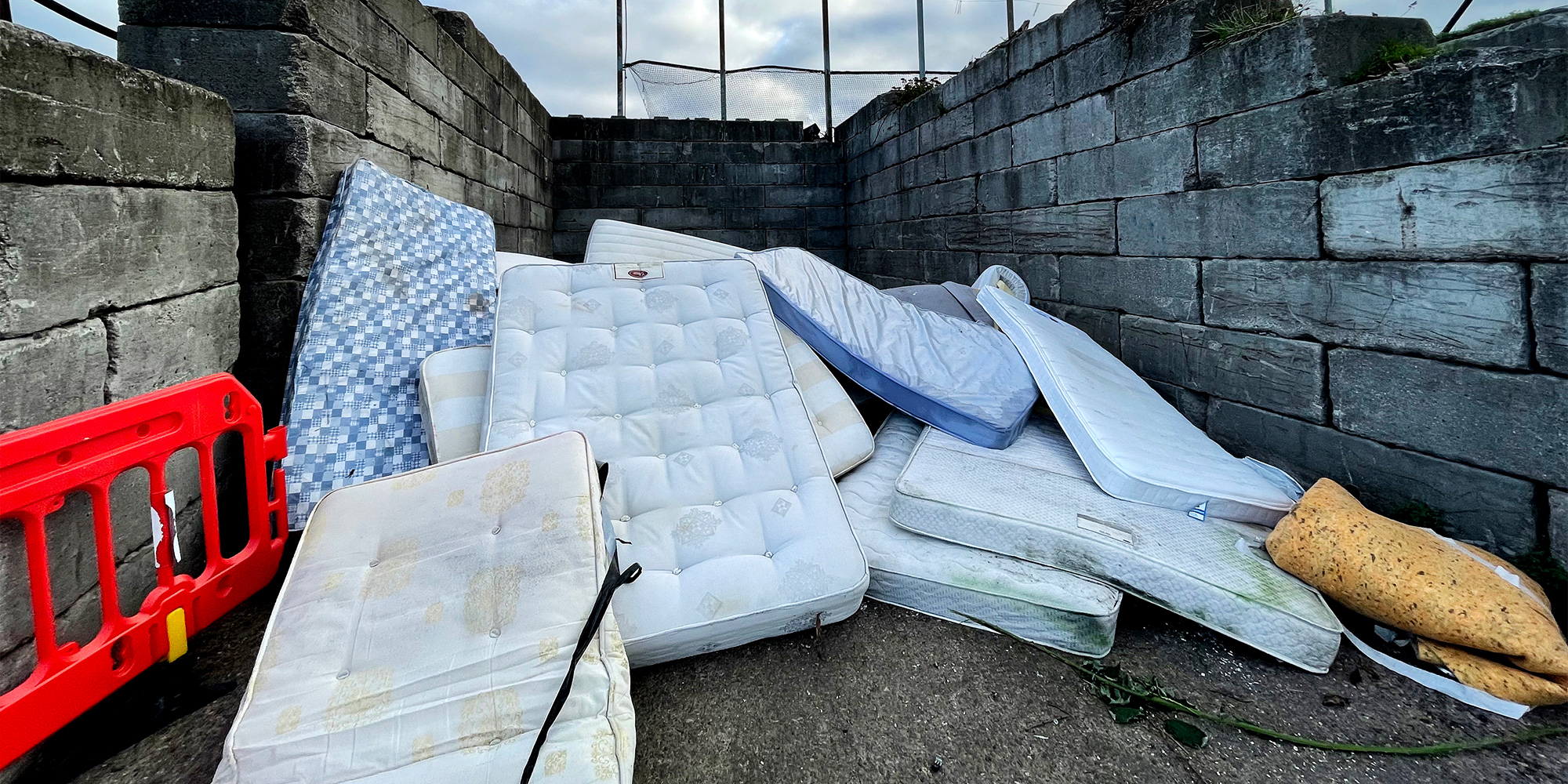 A pile of old mattresses at a rubbish dump