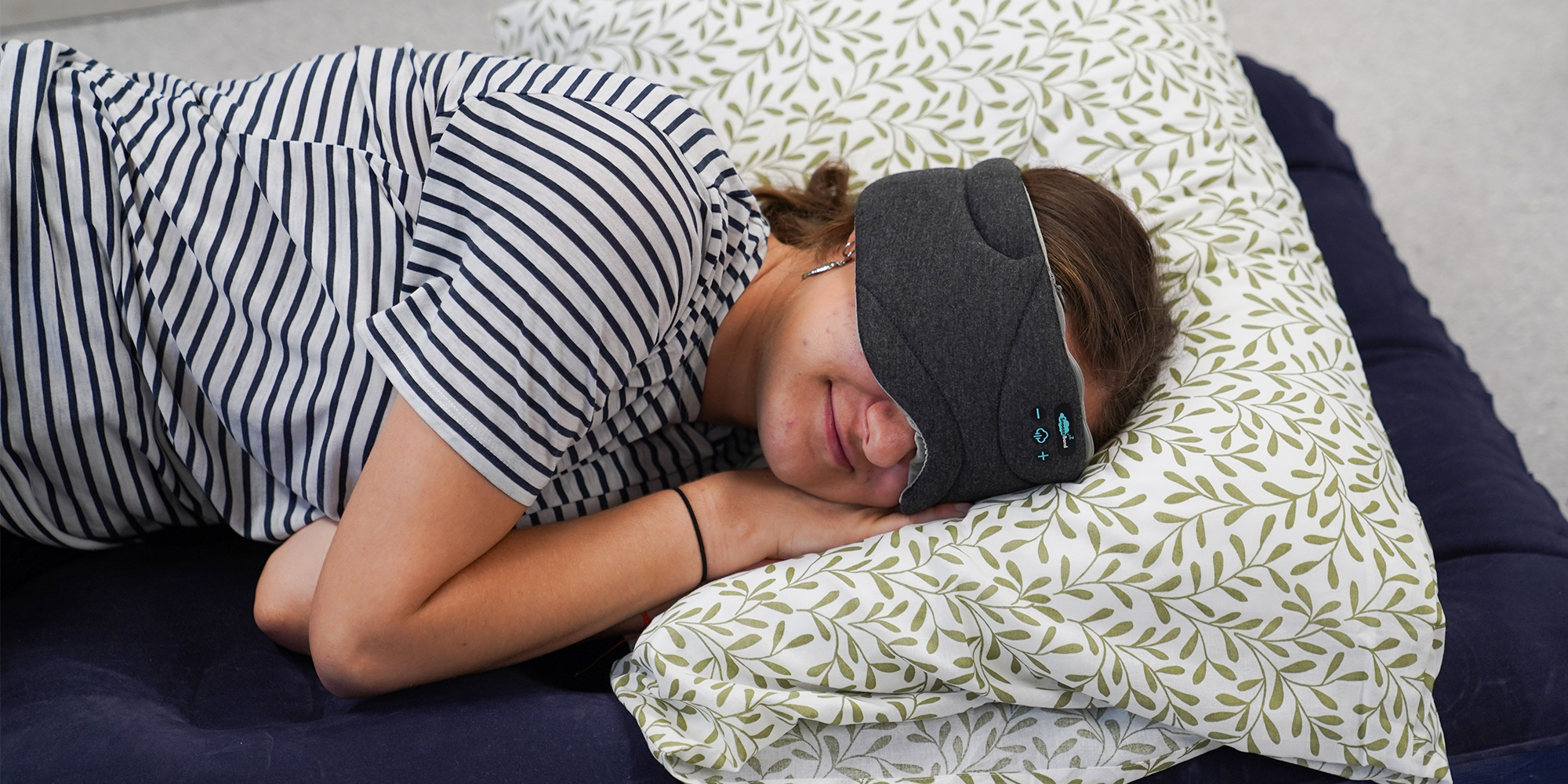 Someone laying on an air bed wearing a bluetooth sleep mask