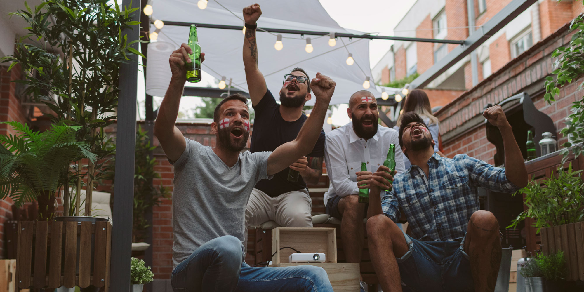 People cheering football in a garden