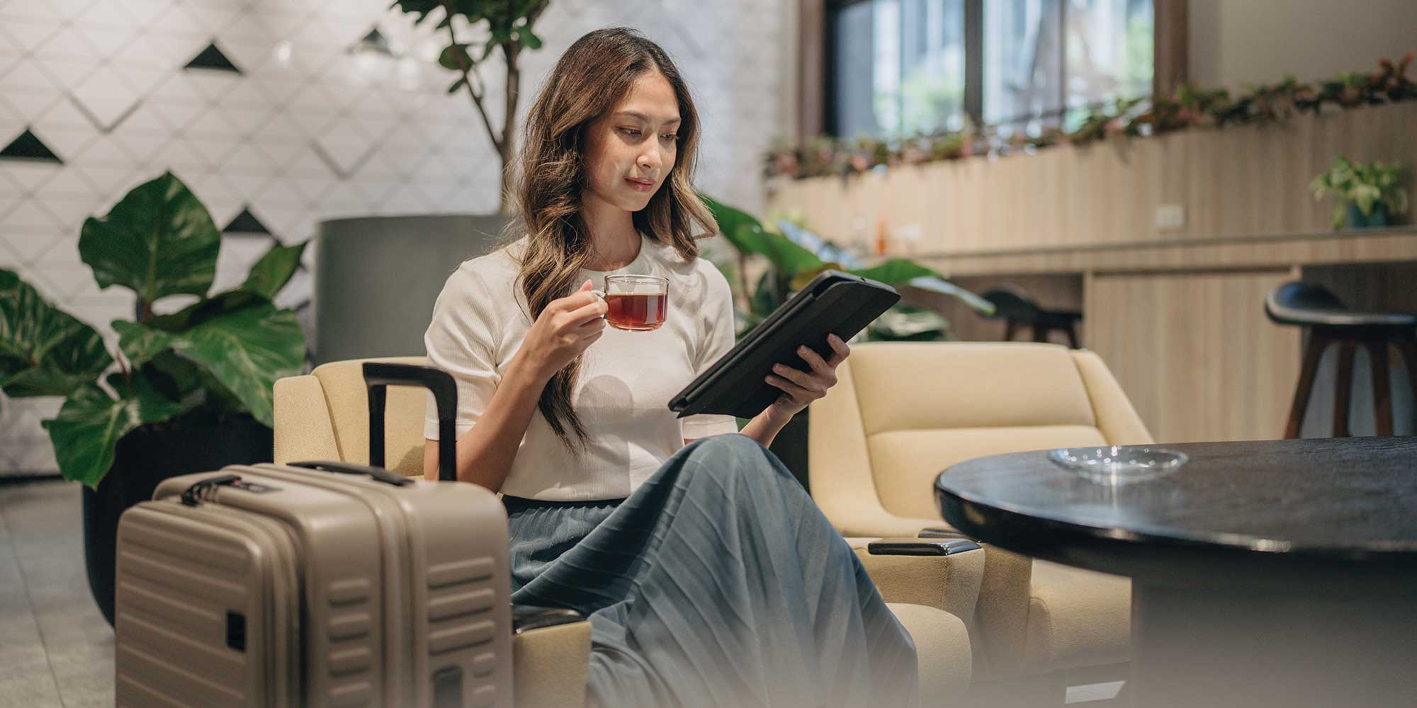 Womean looking at tablet in airport lounge