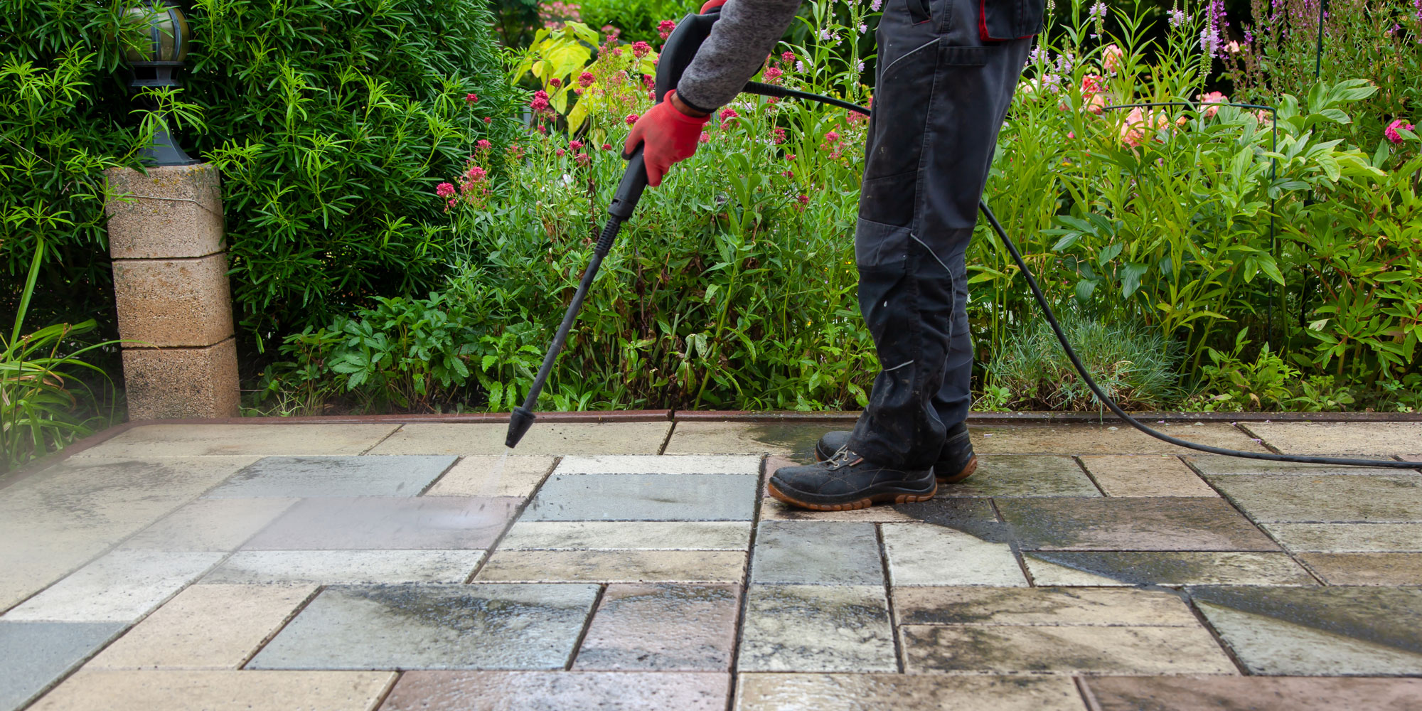 someone wearing protective clothing using pressure washer