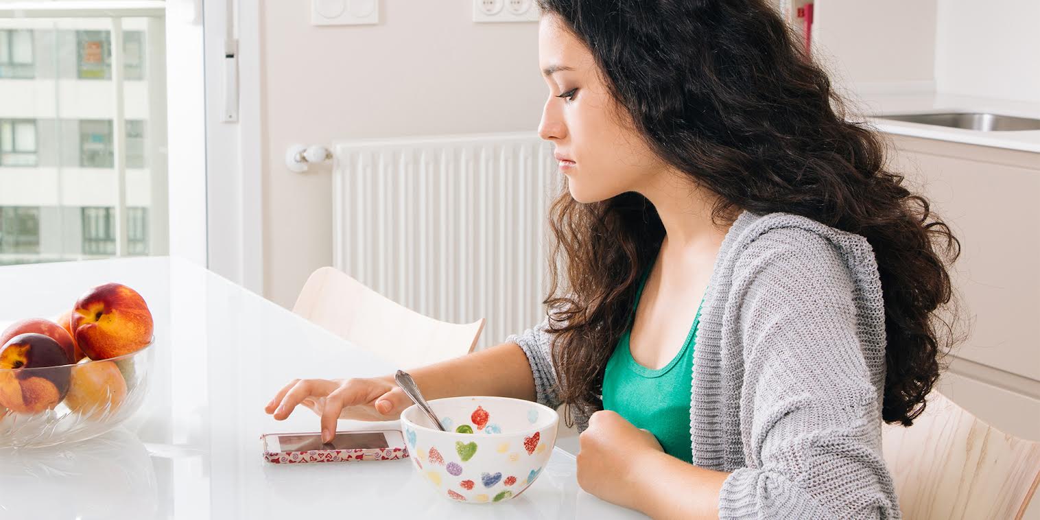 A woman looking pensively at her phone