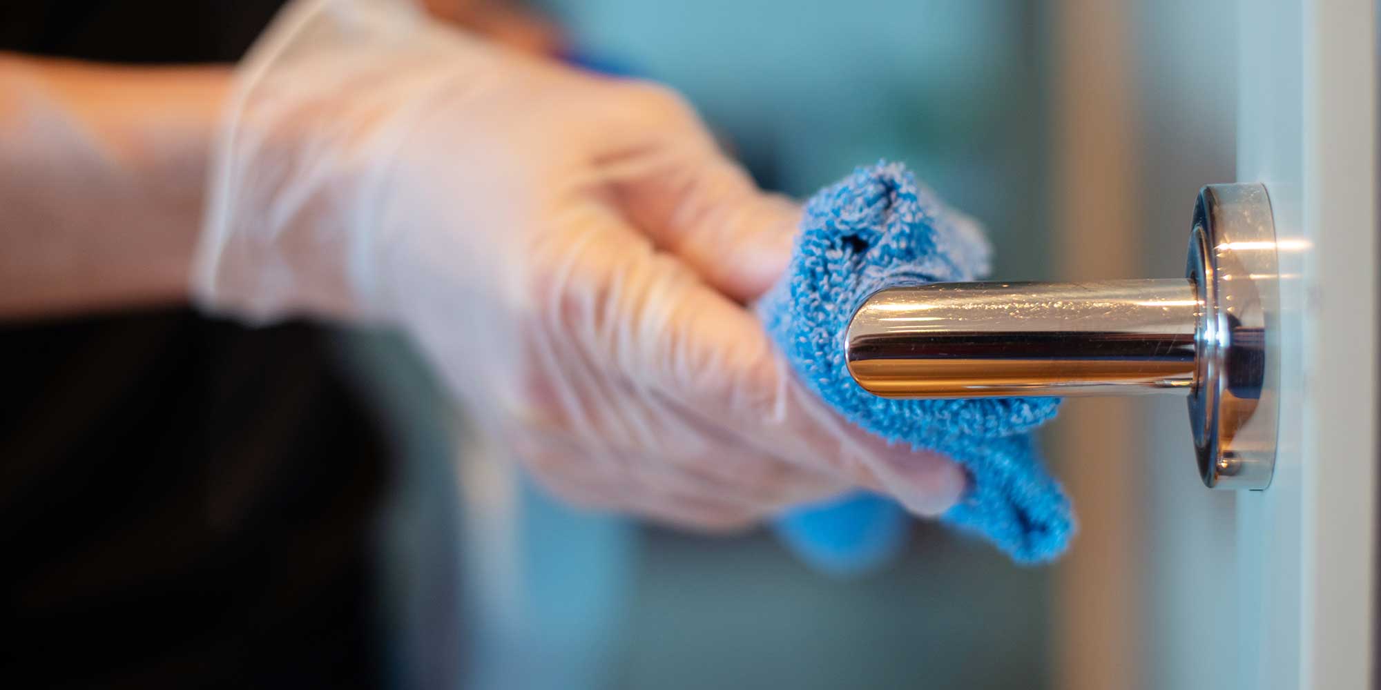 A silver door handle being wiped with a cloth