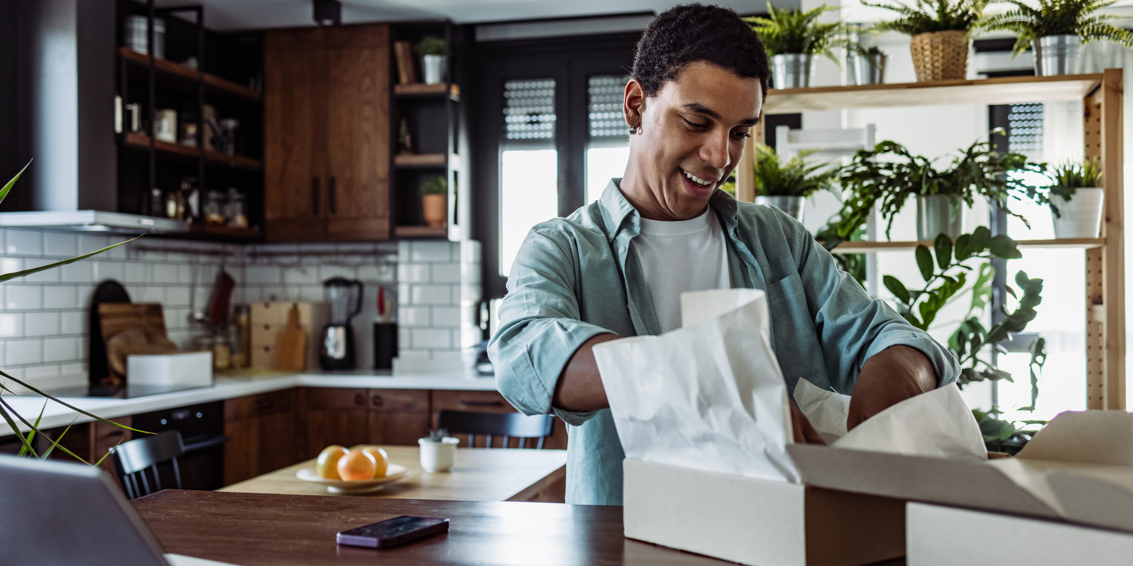 A man opening a package in a kitchen