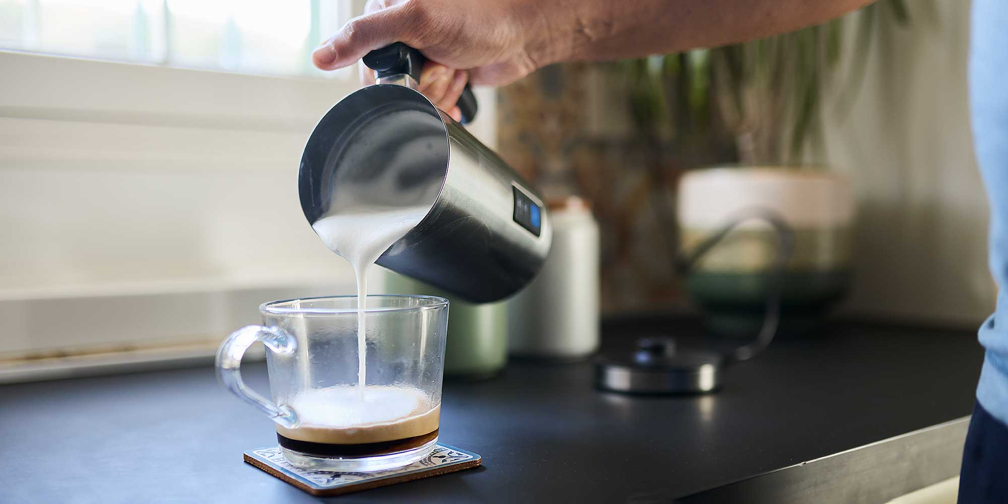 milk frother pouring milk into a mug