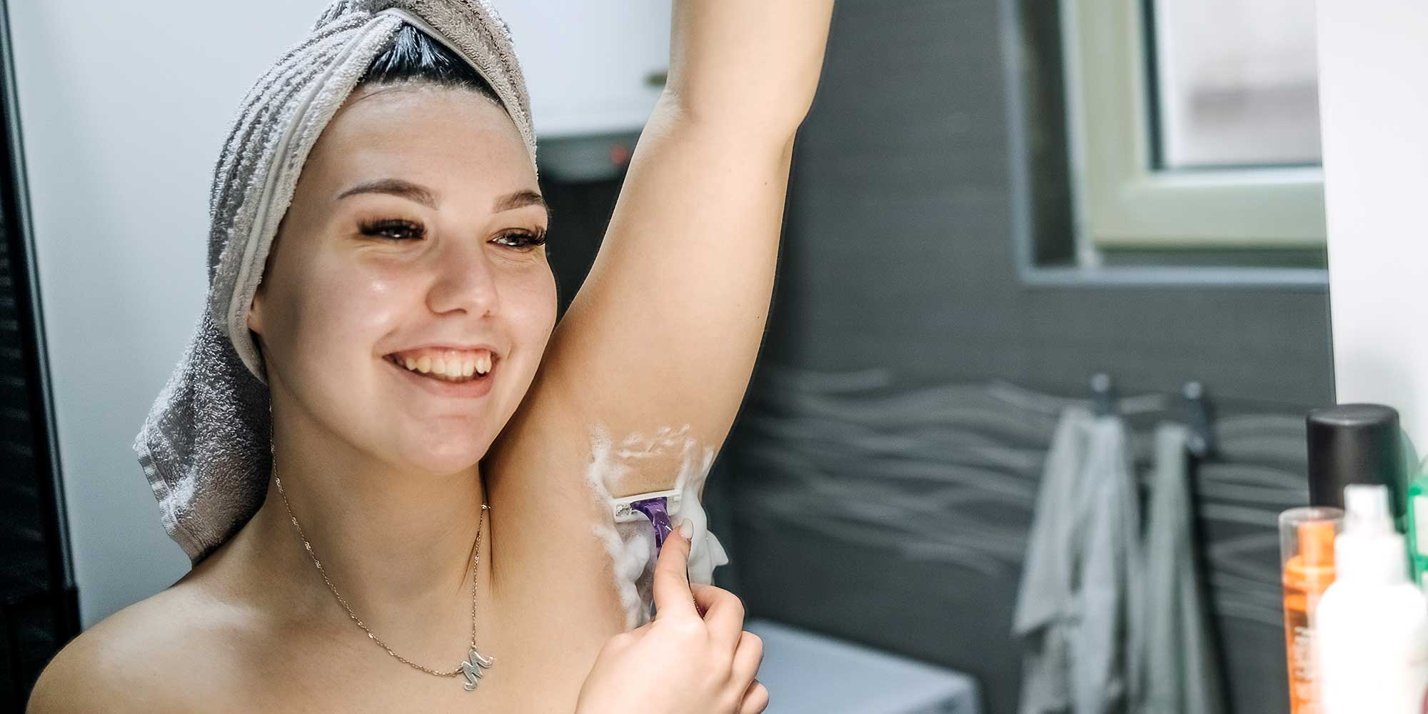 Woman shaving under her arms