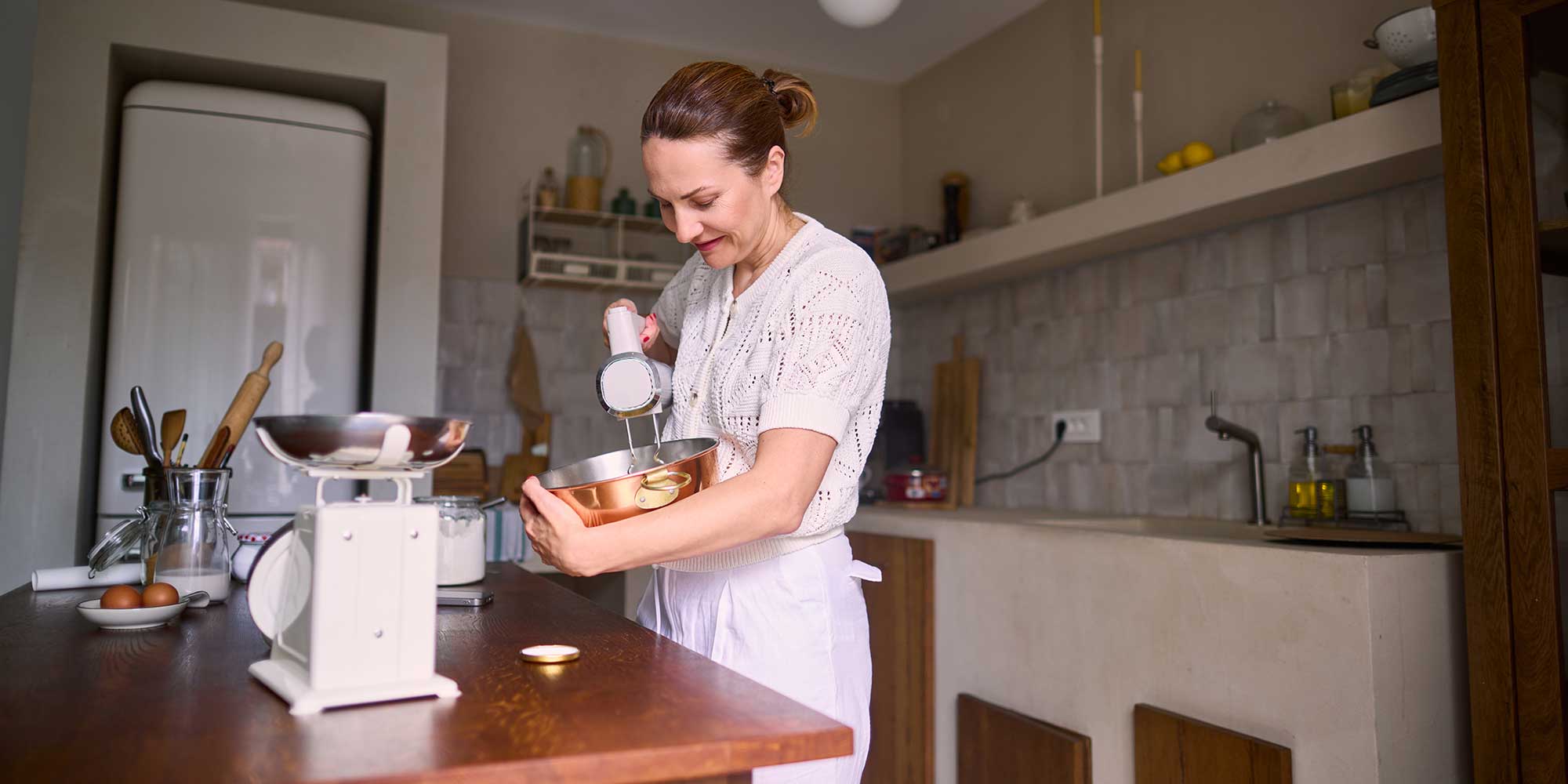 A woman using a hand mixer