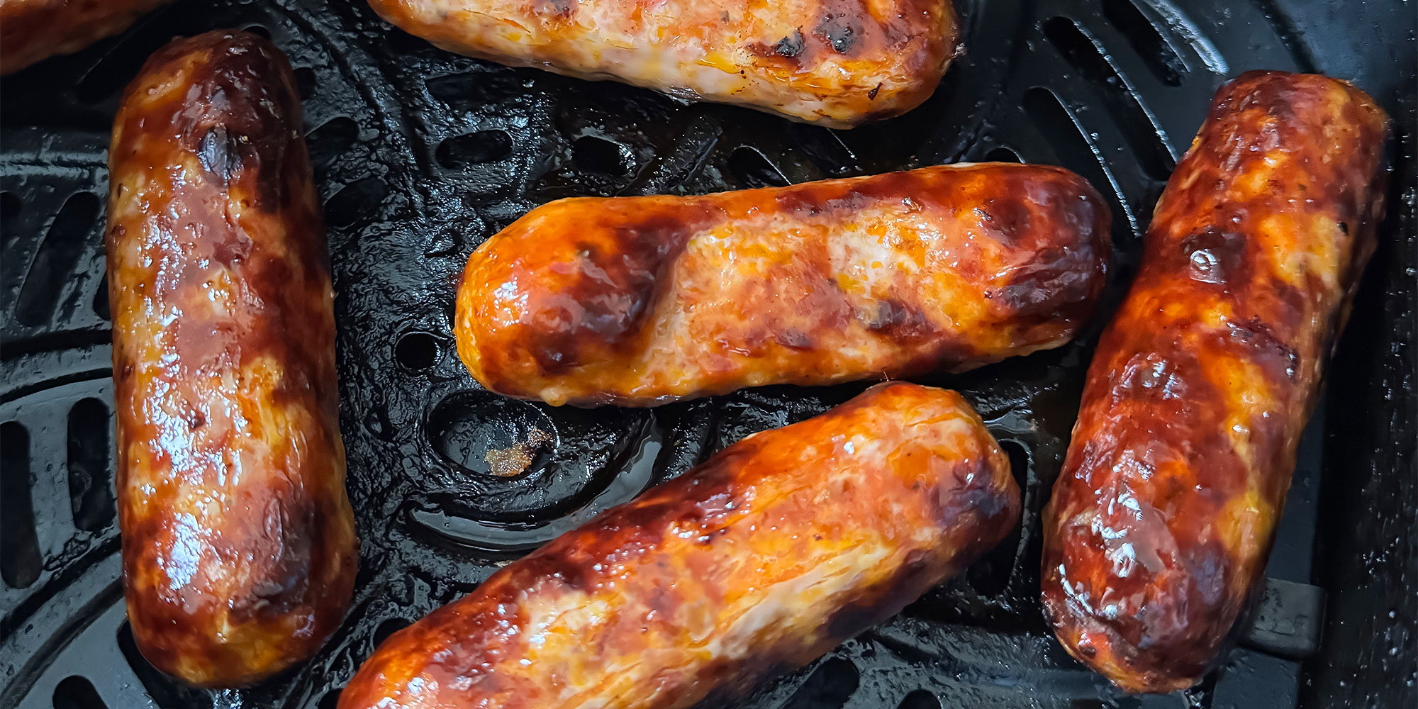Close up of frying sausages