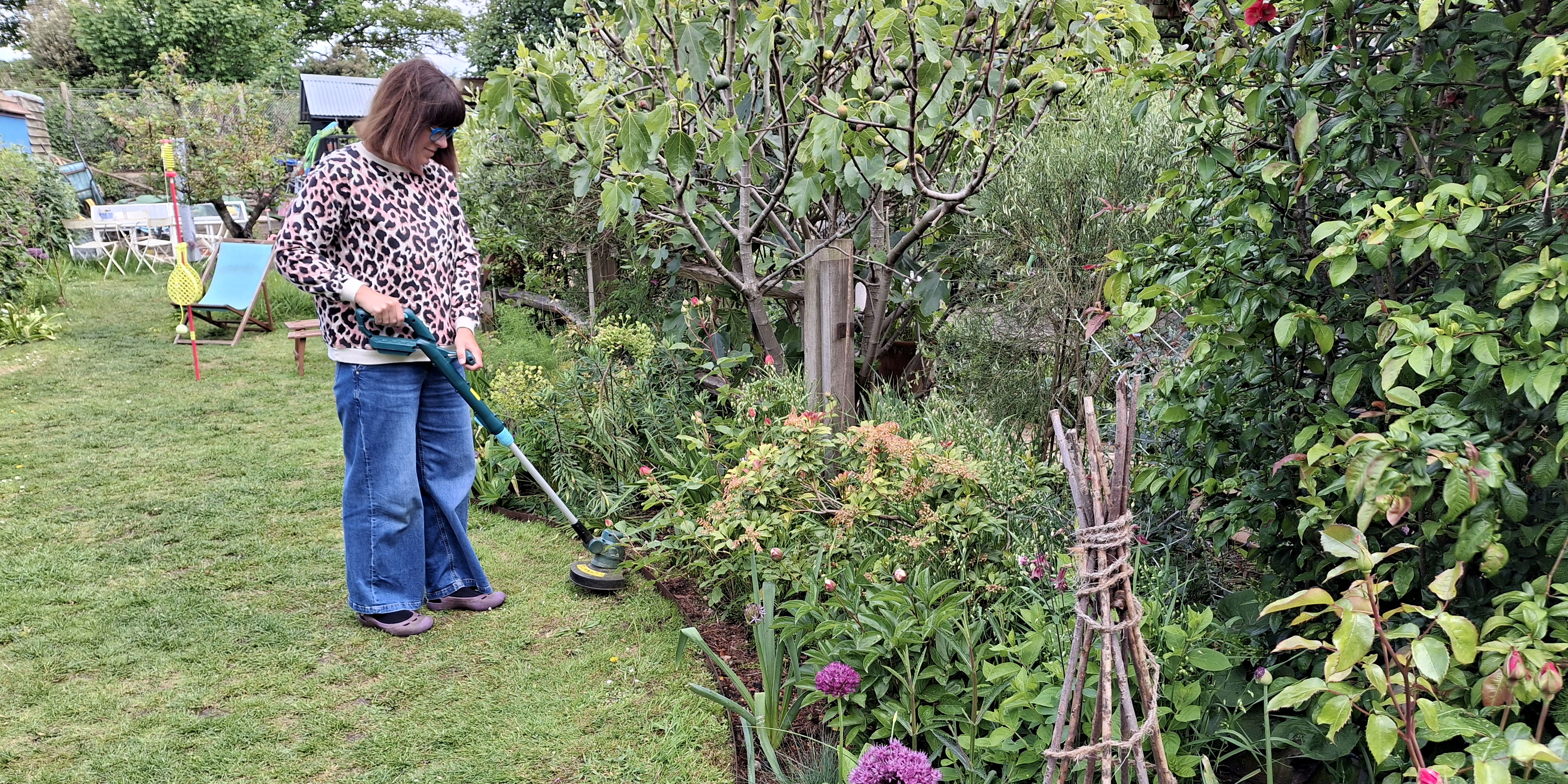 Woman trimming grass with a strimmer