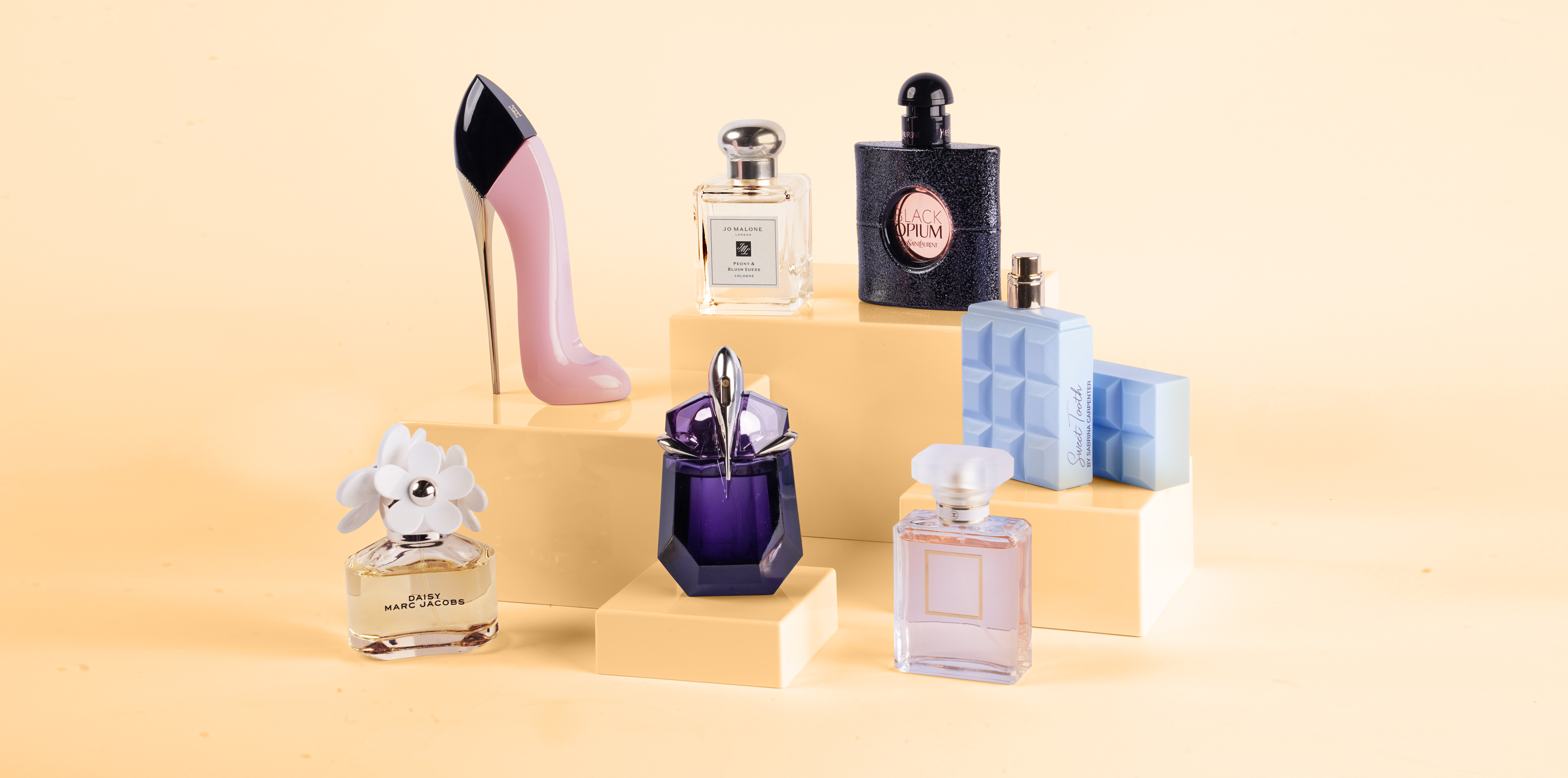 Seven women's perfume bottles against a yellow background
