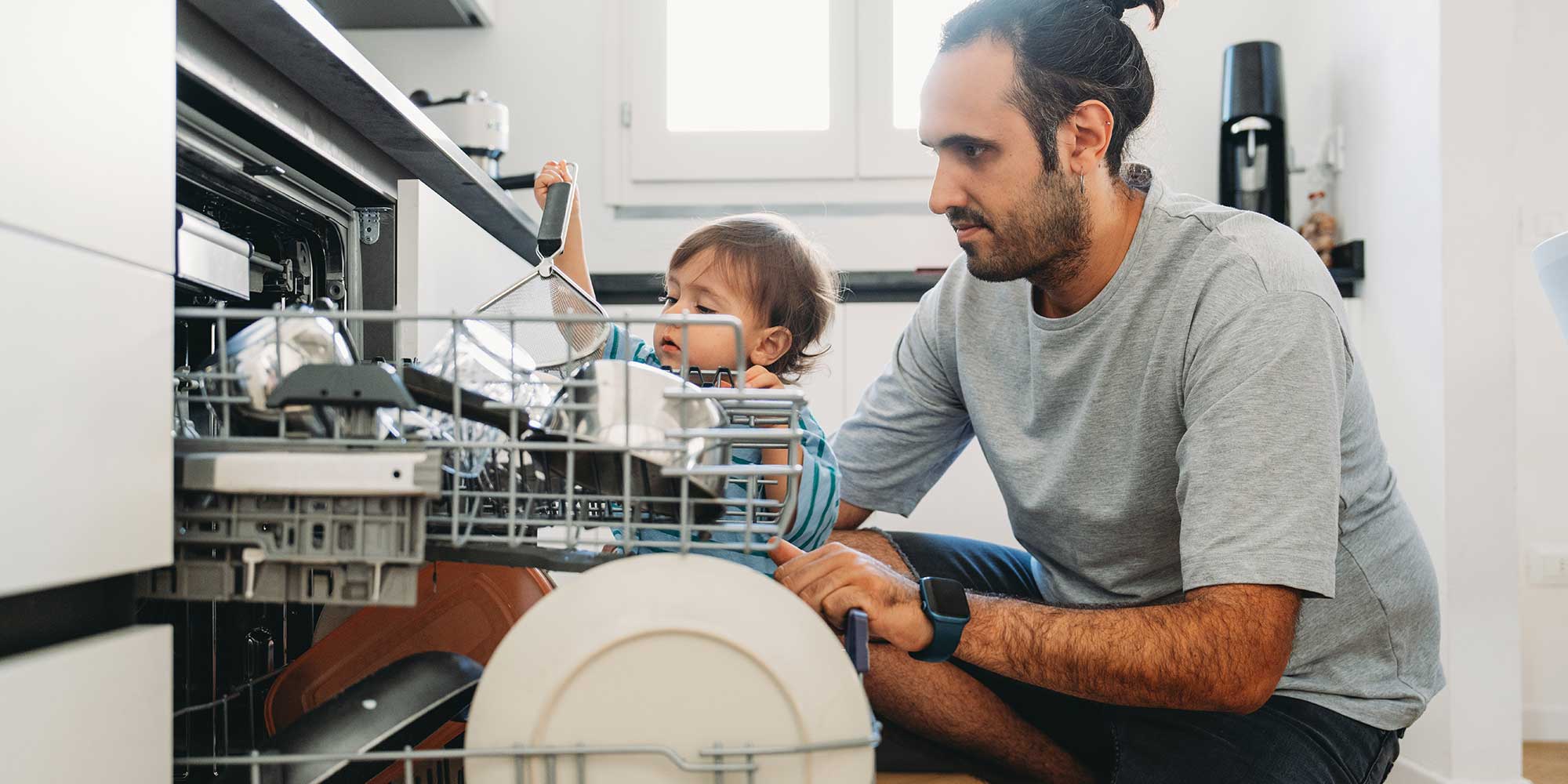 Parent and child unloading a dishwasher