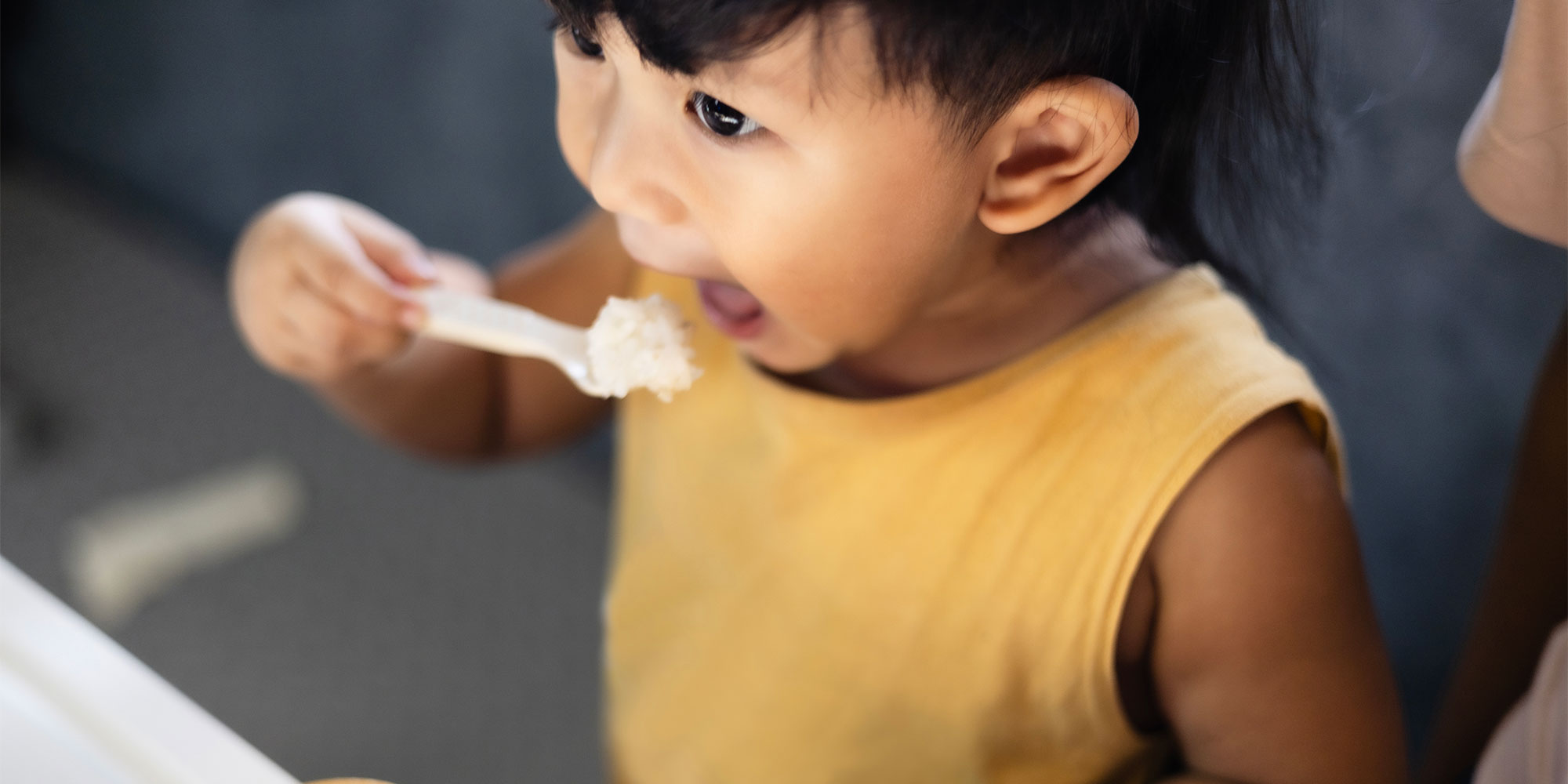 A young child eating rice