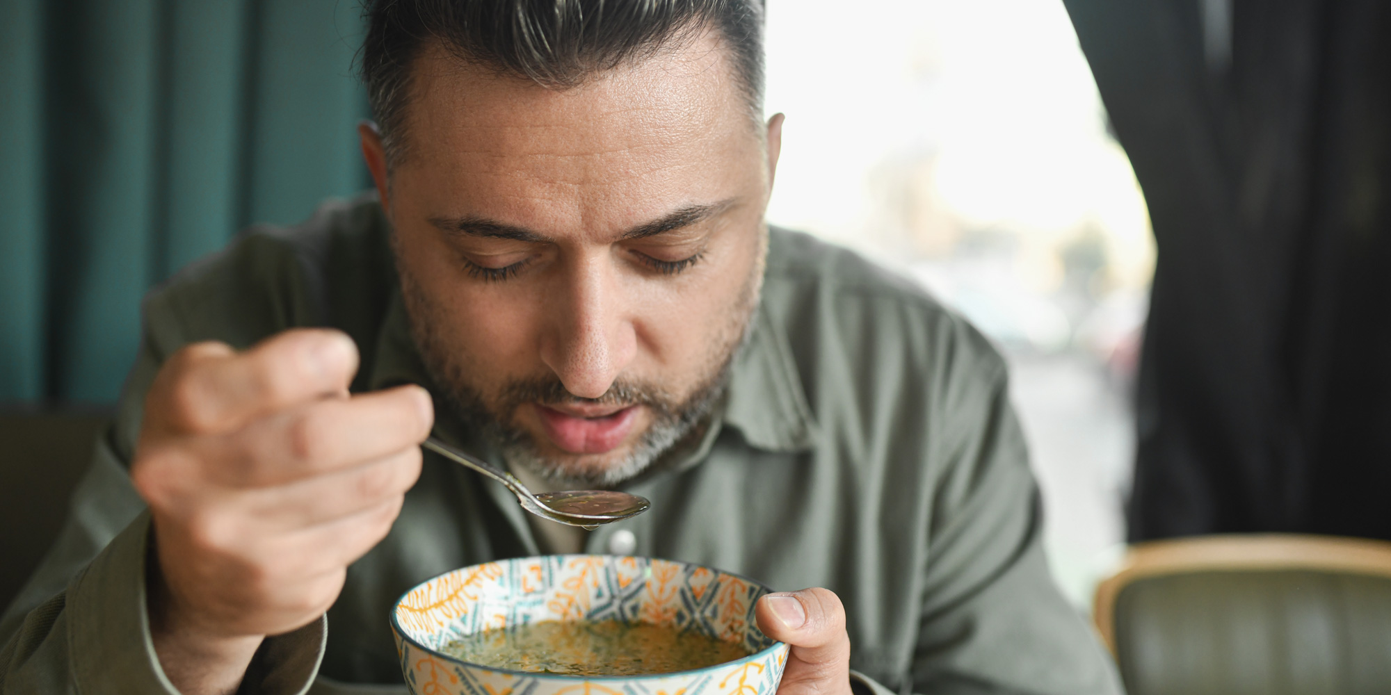 person eating a bowl of soup