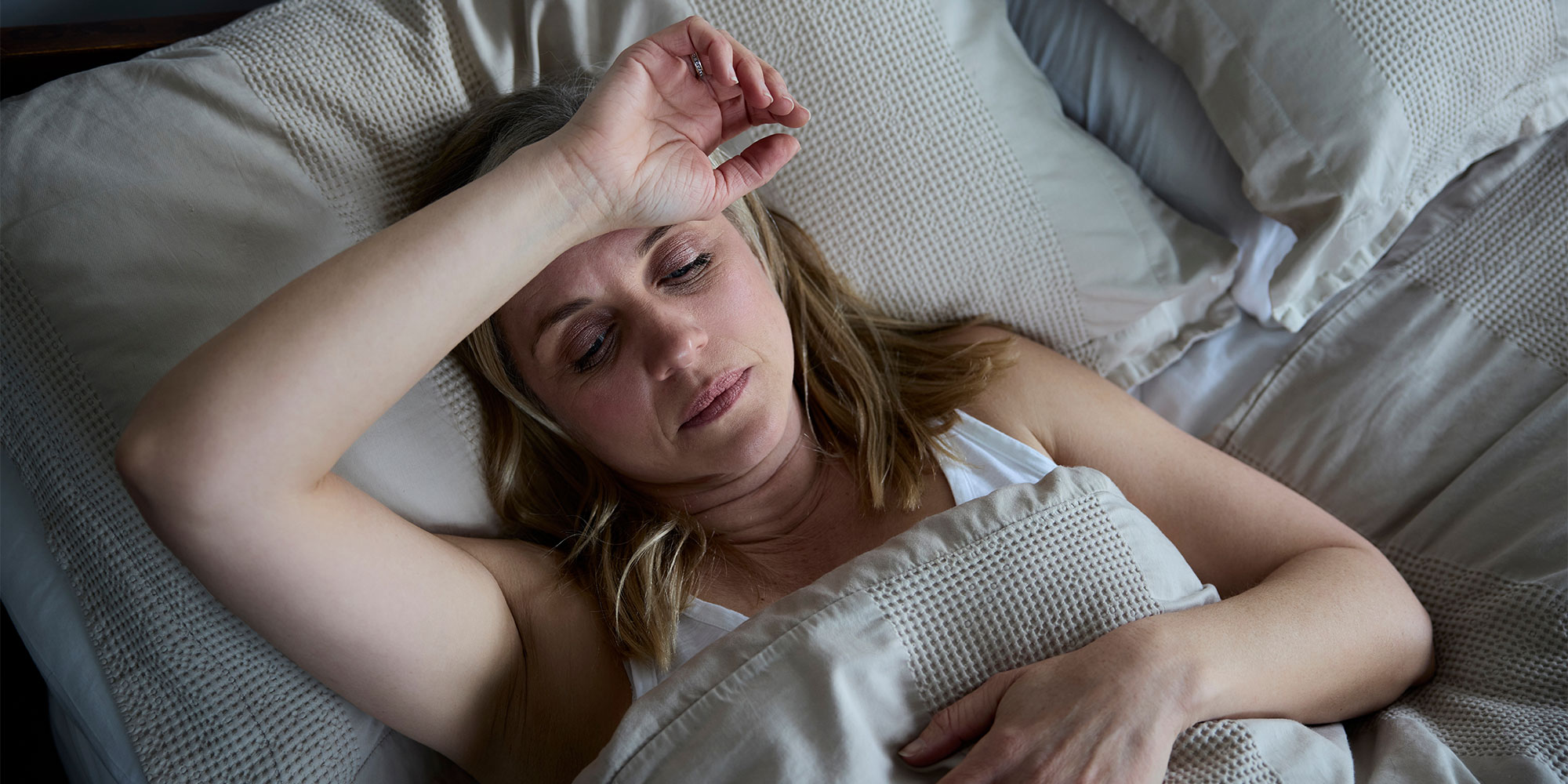 A woman lying awake in bed at night