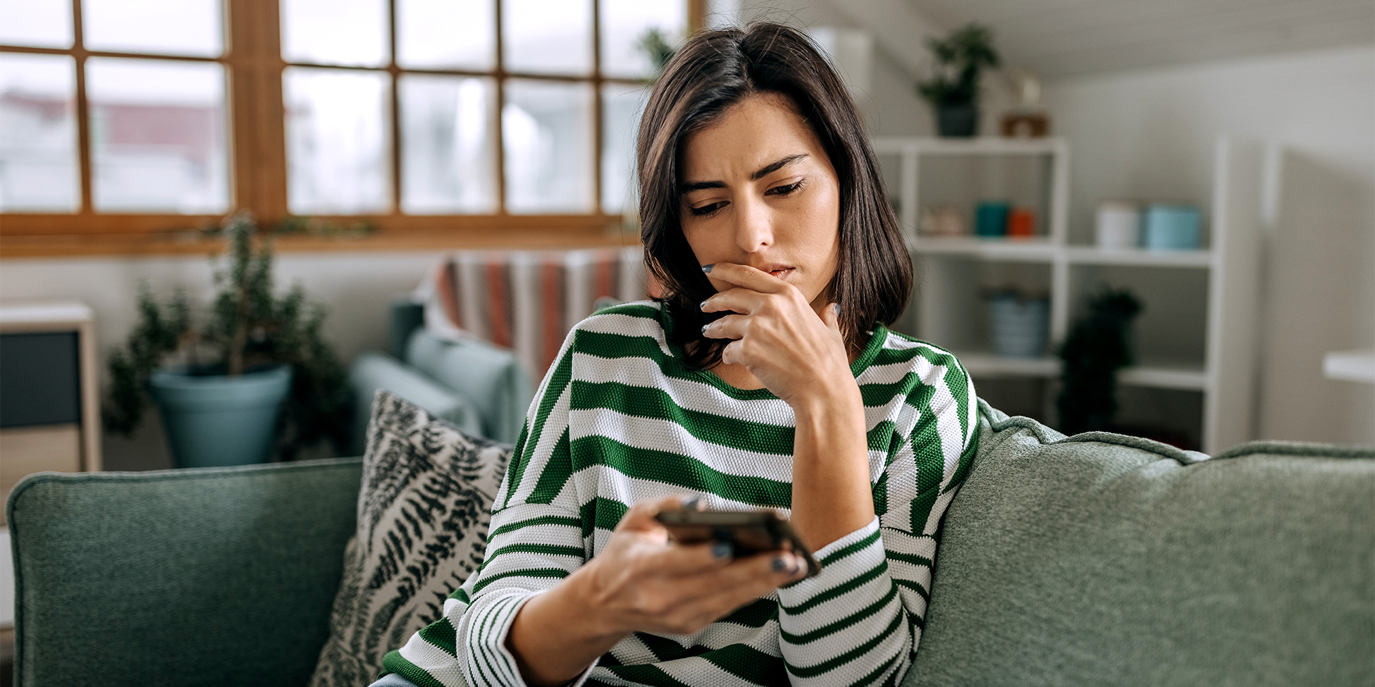 Woman looking at worrying message on her phone