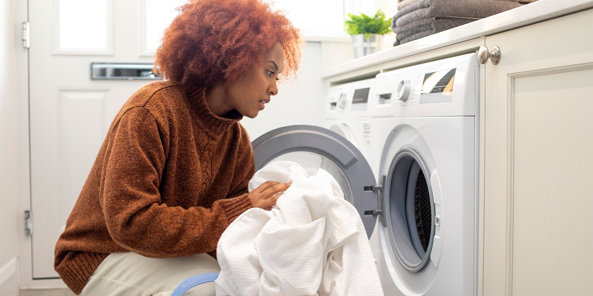 woman loading sheets into washing machine