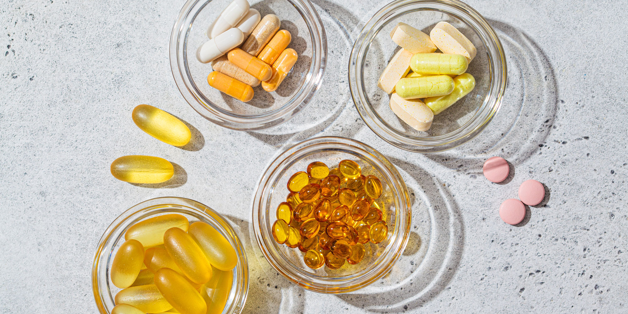Different varieties of vitamin tablets and gels in bowls