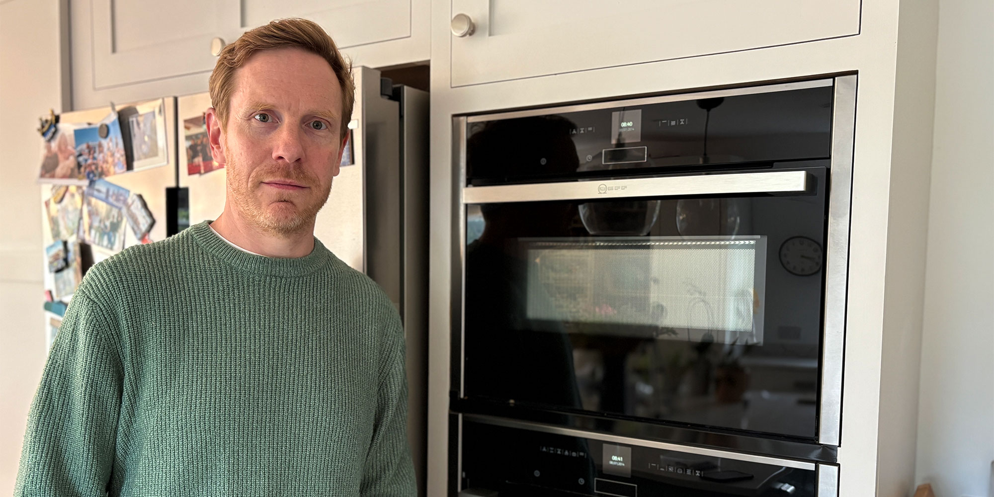 Man leaning against a Neff built-in oven in a kitchen