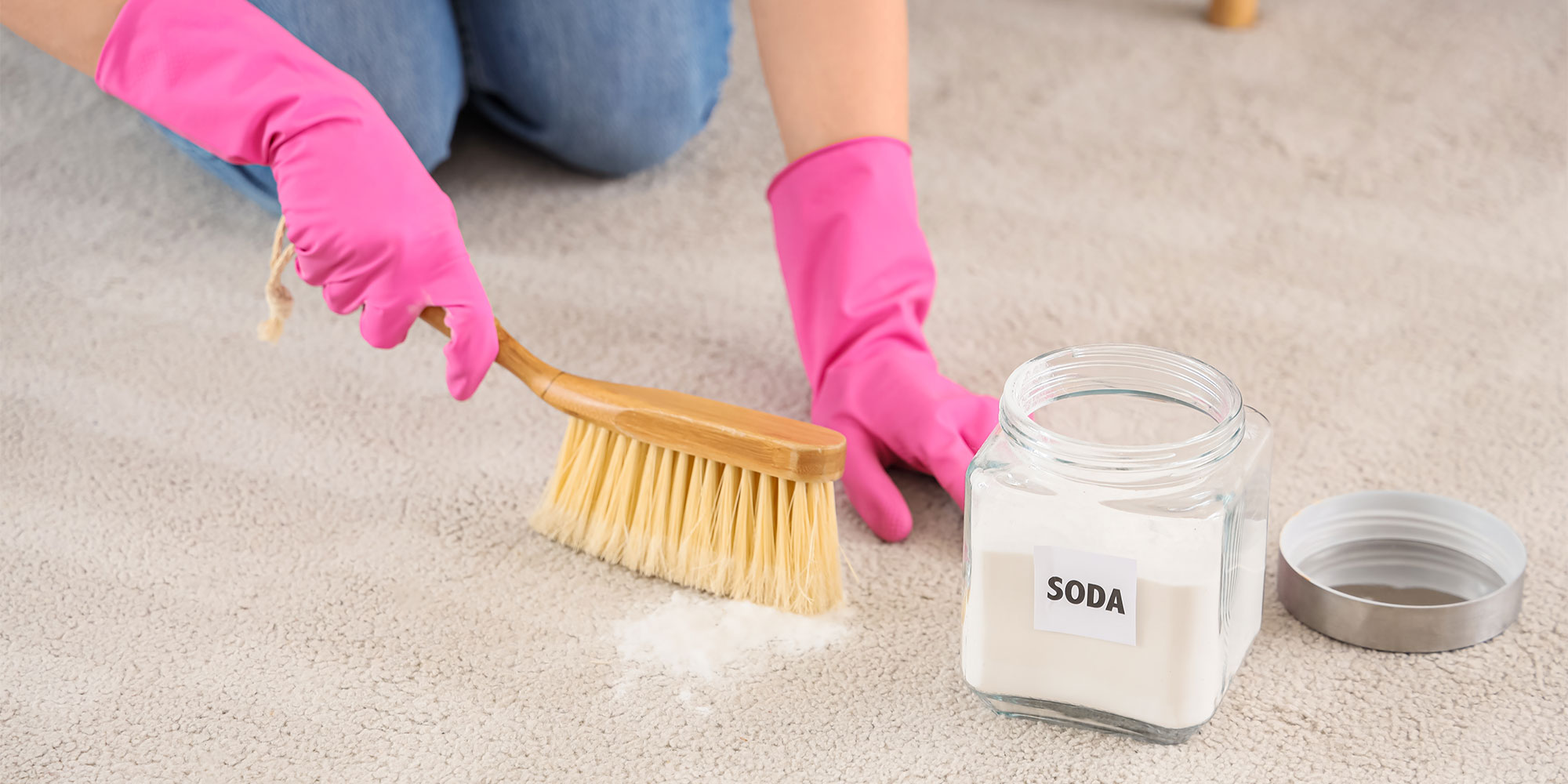 A person cleaning a carpet with bicarbonate of soda