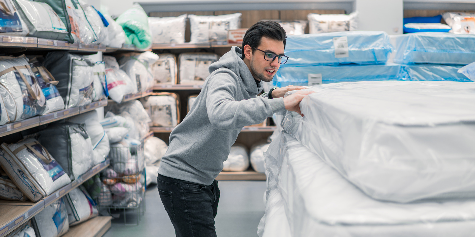 A man checking out mattresses in a store