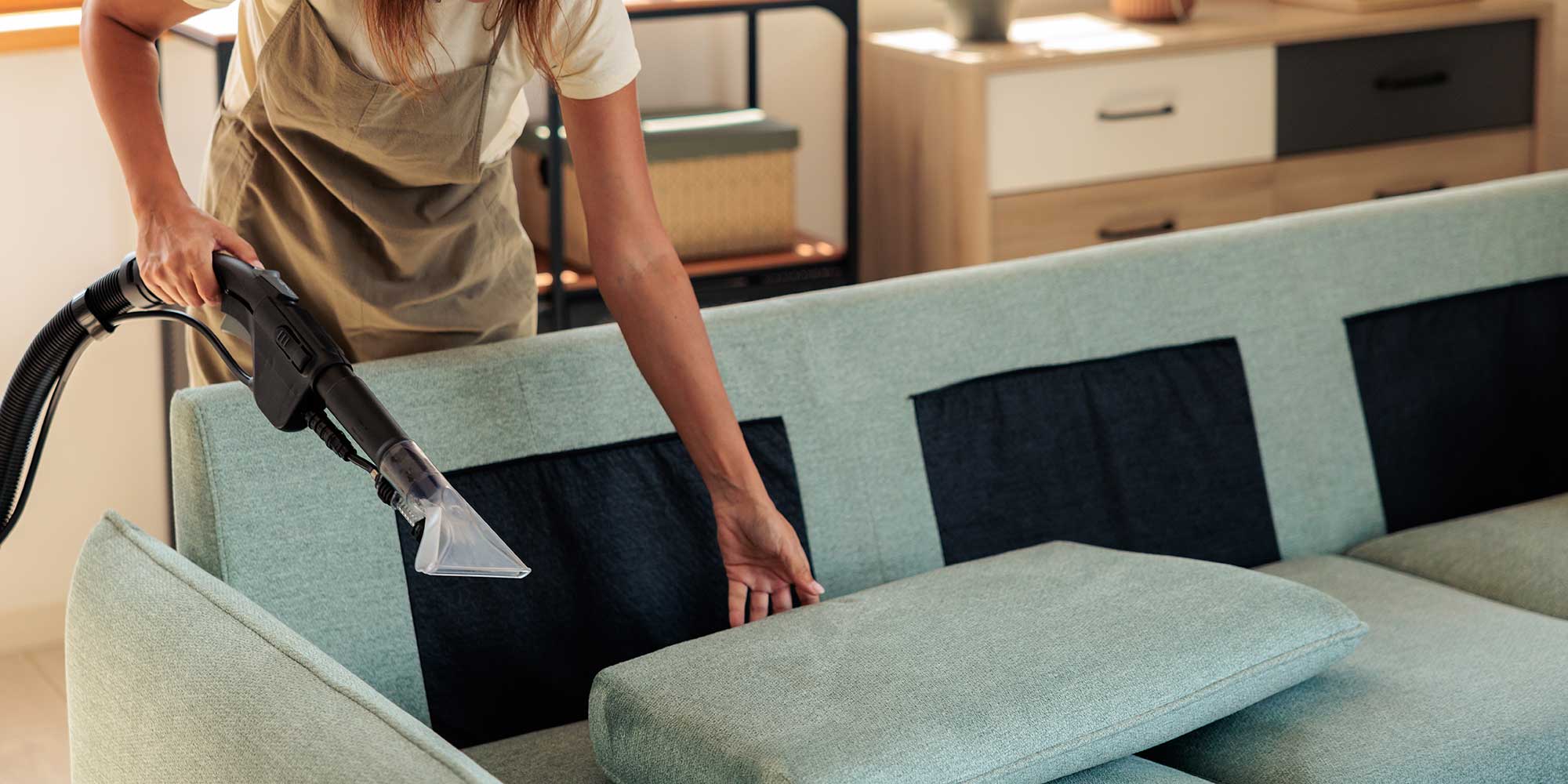 A green sofa being cleaned