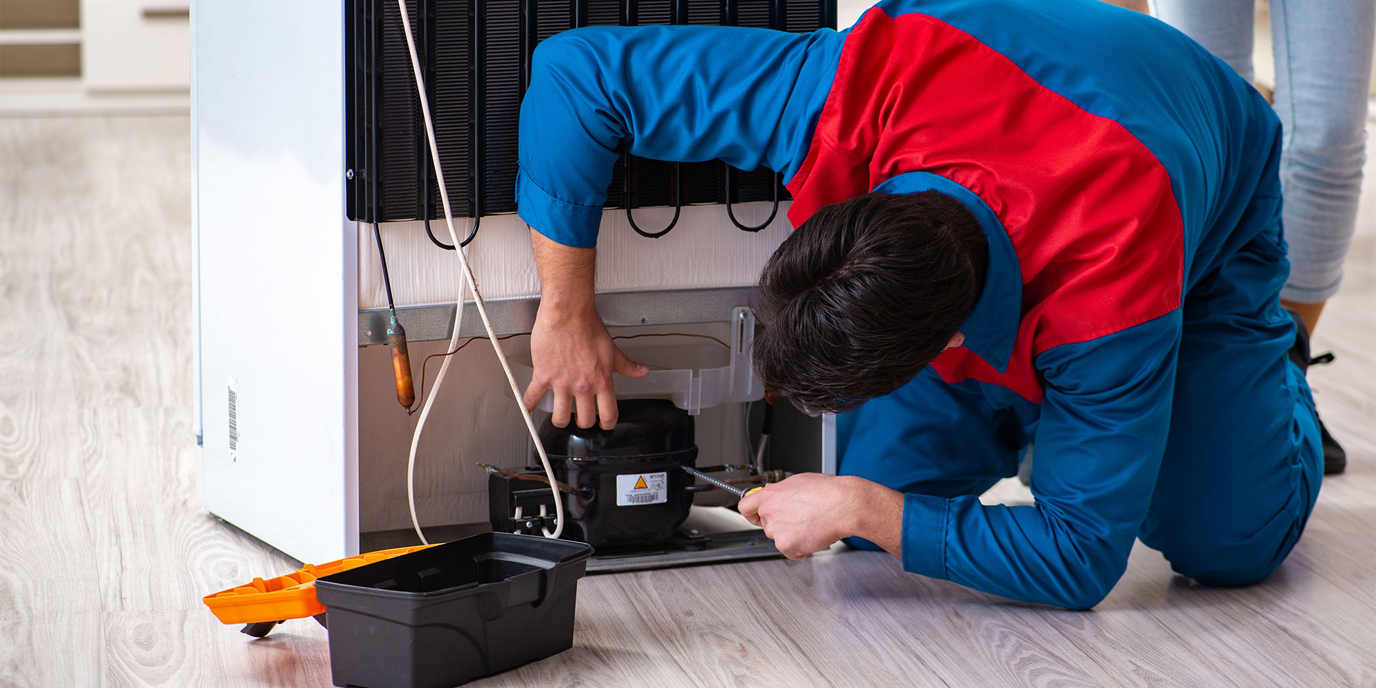 Engineer repairing a fridge freezer