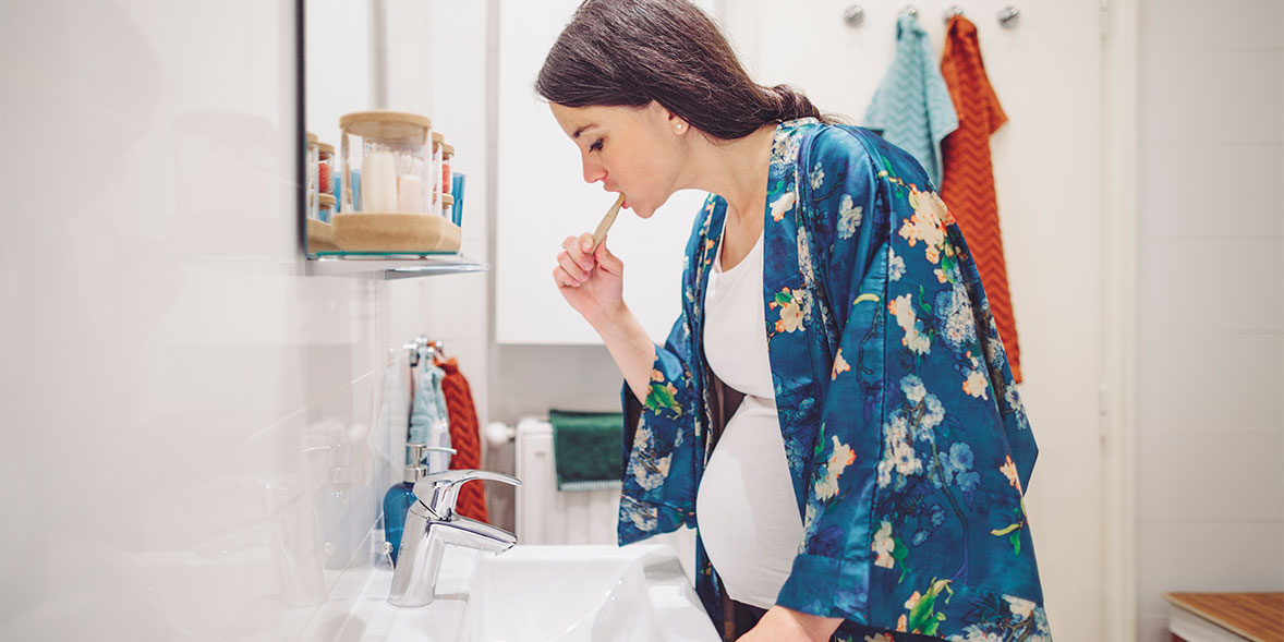 Pregnant woman brushing her teeth