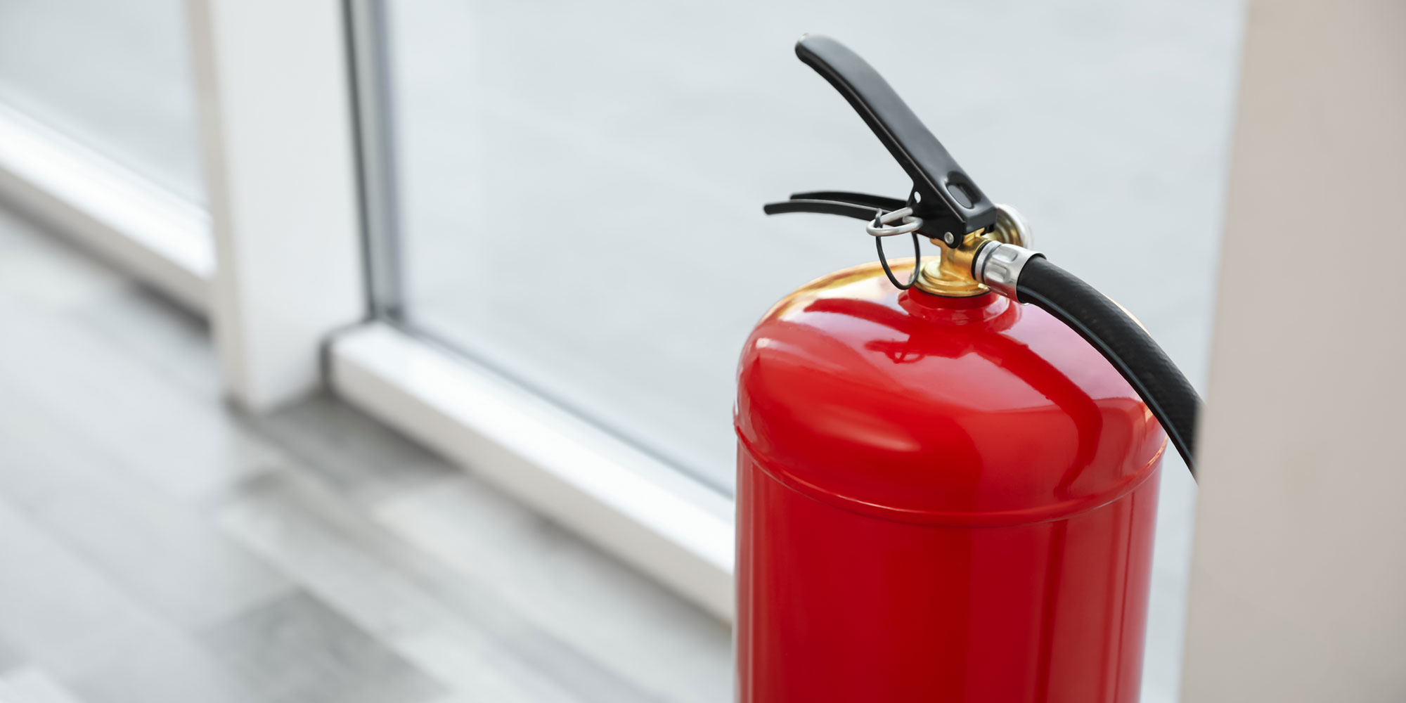 A fire extinguisher next to a large window